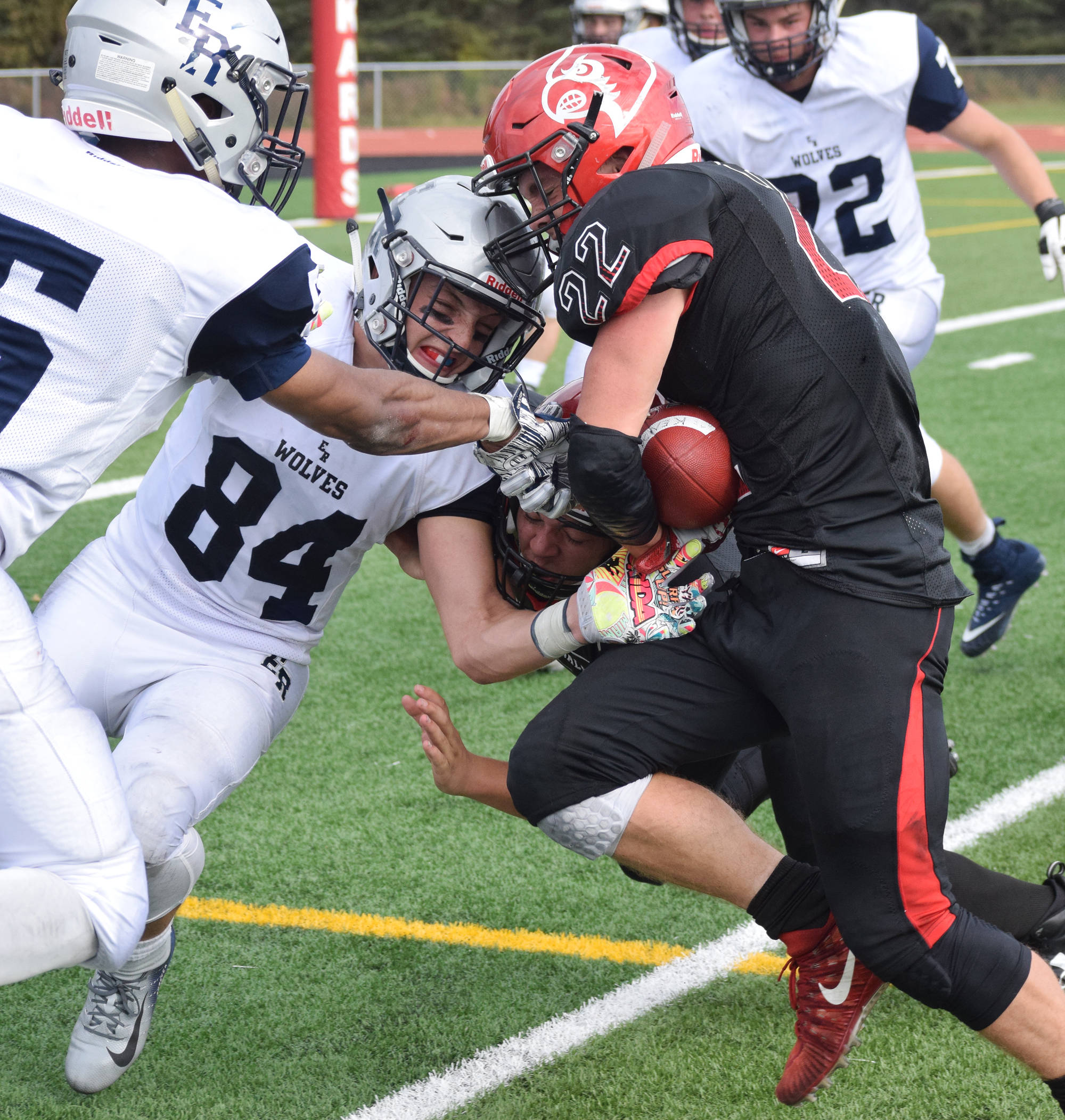 Eagle River defender Mason Piper (84) attempts to knock the ball free from the grasp of Kenai’s Titus Riddall (22) Saturday at Ed Hollier Field in Kenai. (Photo by Joey Klecka/Peninsula Clarion)