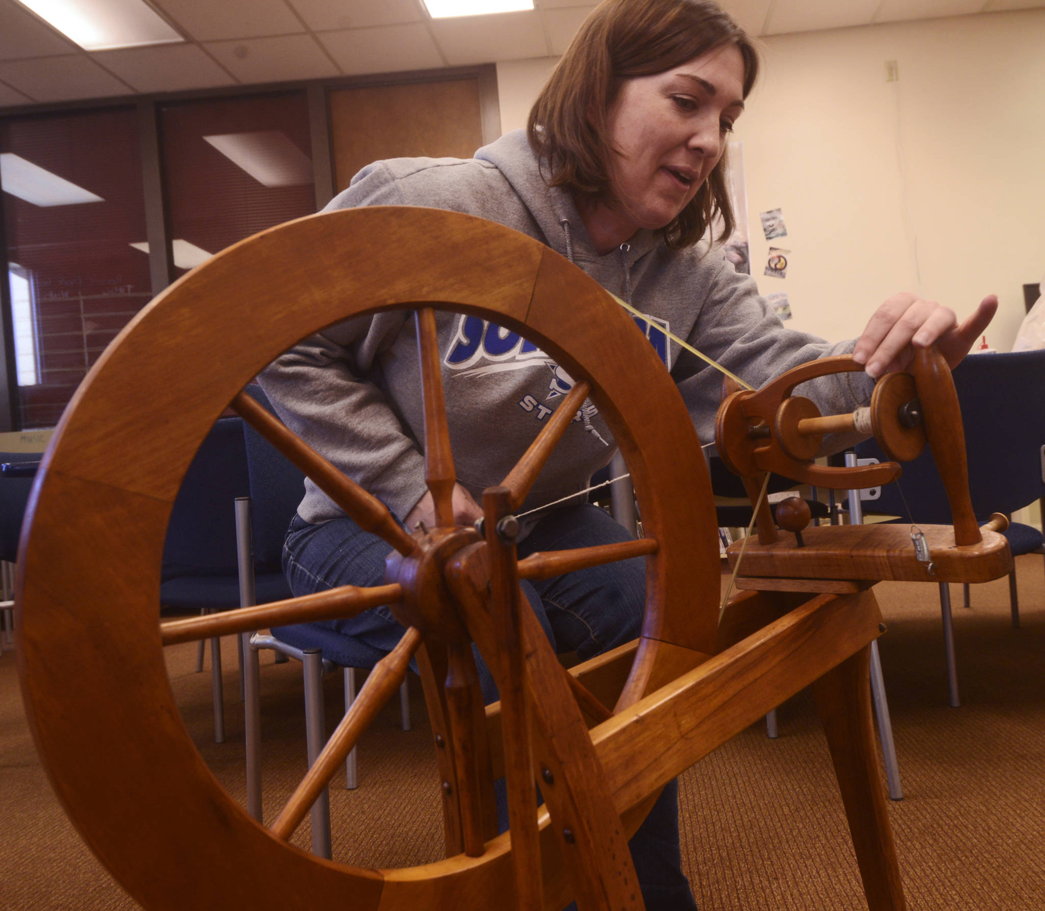 Suzanne Hall prepares to spin wool into yarn during the first session of the Soldotna Community Schools yarn-spinning class on Tuesday, March 20 in the library of the Soldotna Preparatory School in Soldotna, Alaska. (Ben Boettger/Peninsula Clarion)