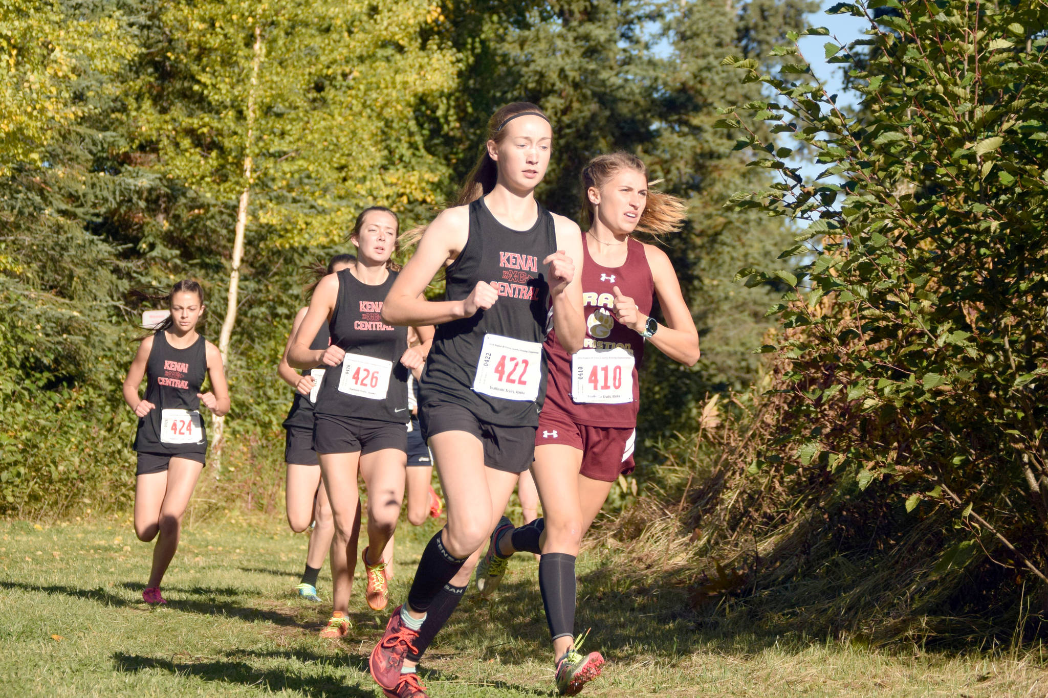 Kenai Central’s Jaycie Calvert leads Grace Christian’s Mazzy Jackson, and Kenai Central’s Brooke Satathite and Summer Foster, early in the Division II girls race at the Region 3 meet Saturday, Sept. 22, 2018, at Tsalteshi Trails. (Photo by Jeff Helminiak/Peninsula Clarion)