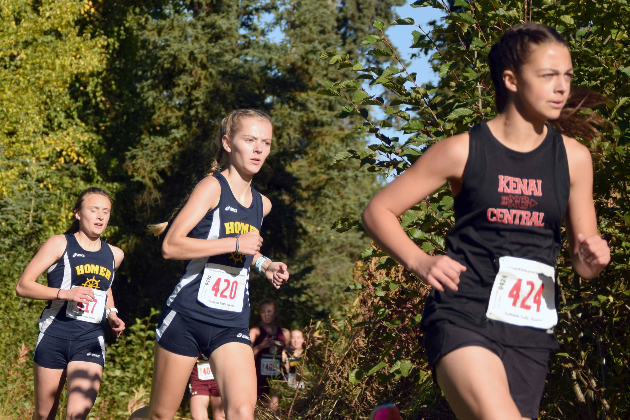 Kenai Central’s Summer Foster is chased by Homer’s Brooke Miller and Autumn Daigle on Saturday, Sept. 22, 2018, in the Division II girls race at the Region 3 meet at Tsalteshi Trails. (Photo by Jeff Helminiak/Peninsula Clarion)