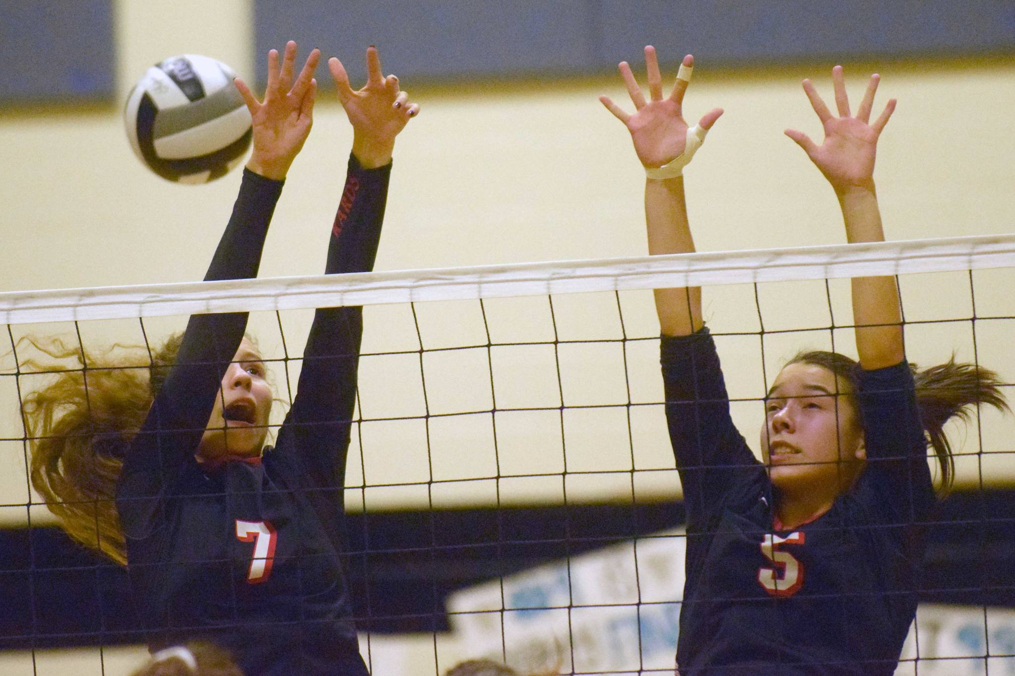 Kenai Central’s Lexi Reis and Chelsea Plagge go up for a block Tuesday, Sept. 25, 2018, against Nikiski at Nikiski High School. (Photo by Jeff Helminiak/Peninsula Clarion)