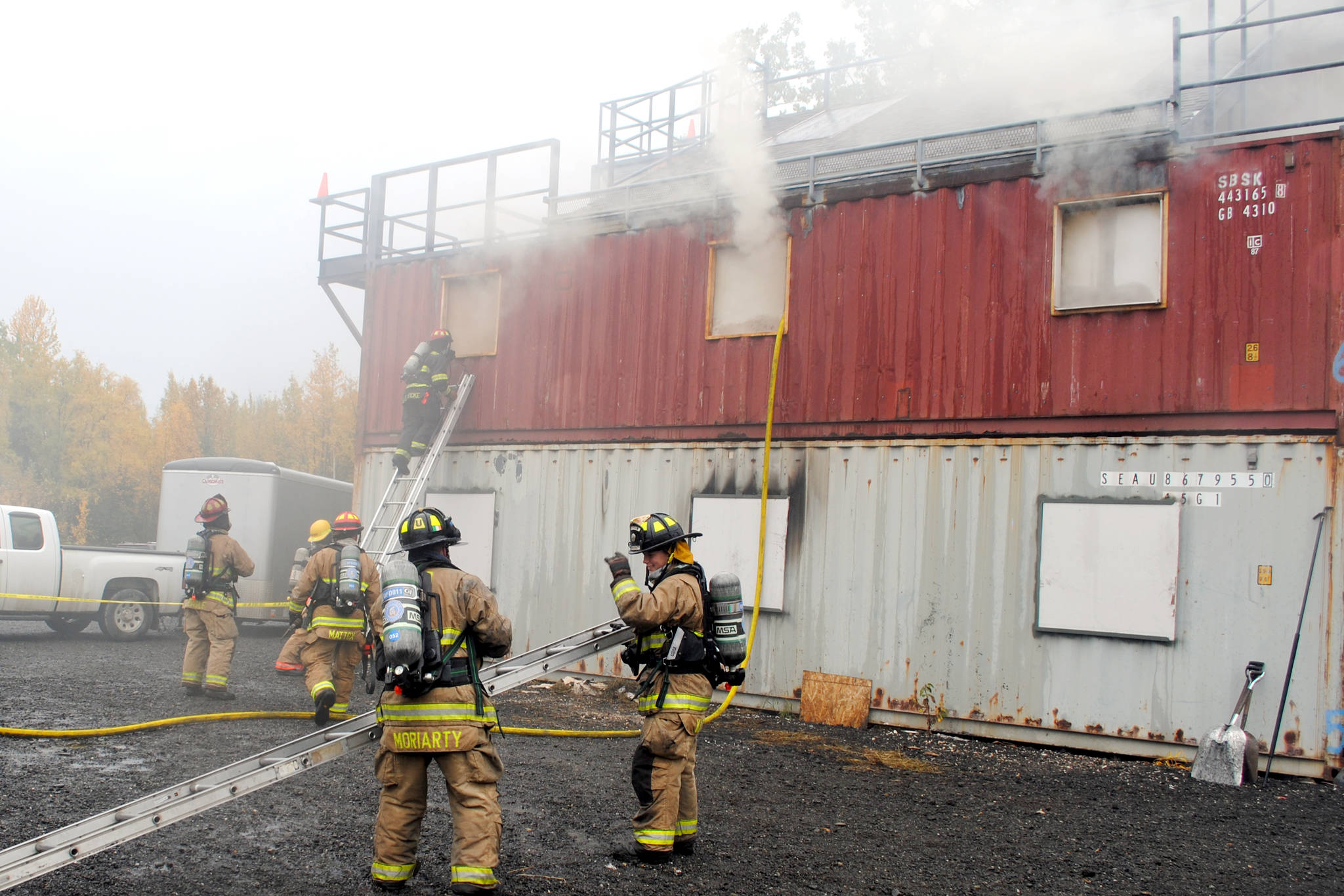 Firefighters respond to a controlled fire in a group of conexes off of Arc Loop Road in Soldotna. The area was set up to resemble a home and a fire was set in different sections of the building to test the firefighters. The training on Thursday was part of the Alaska Fire Conference which is being held in Kenai this week. (Photo by Kat Sorensen/Peninsula Clarion)