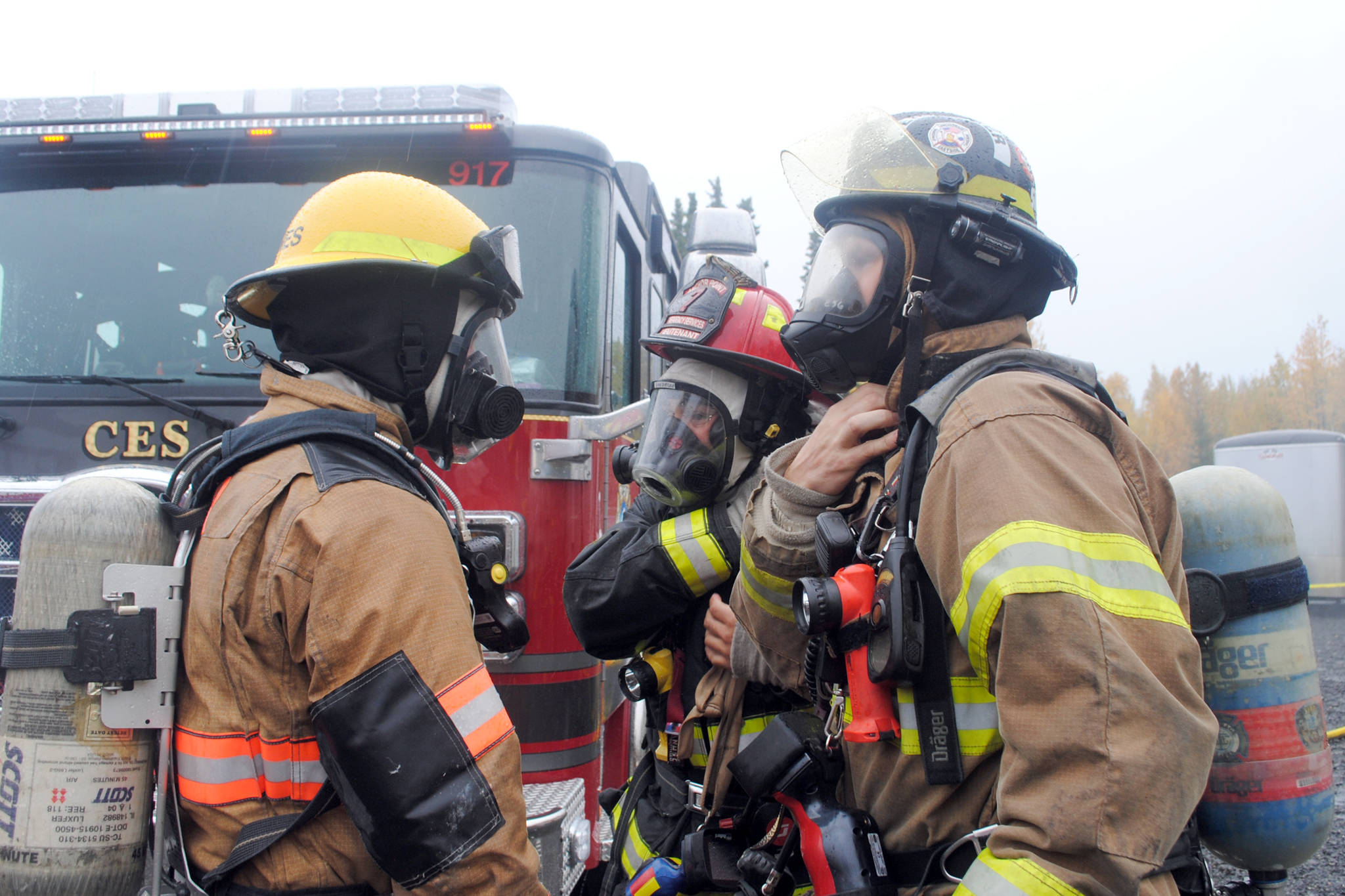 <strong>ABOVE: </strong>Firefighters prepare for a training session off Arc Loop Road on Thursday as part of the Alaska Fire Conference.                                 <strong>BELOW: </strong>Firefighters respond to a controlled fire in a group of conexes off of Arc Loop Road in Soldotna. The area was set up to resemble a home and a fire was set in different sections of the building to test the firefighters. The training on Thursday was part of the Alaska Fire Conference which is being held in Kenai this week. (Photo by Kat Sorensen/Peninsula Clarion)