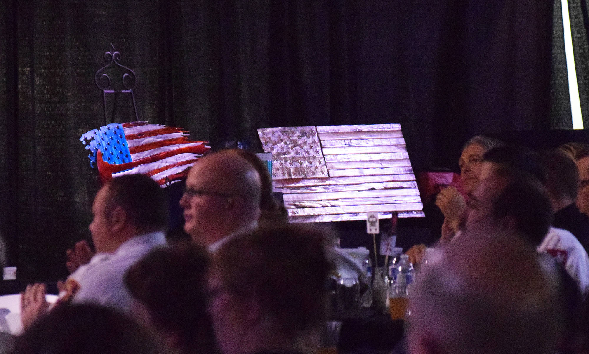 A pair of American flag design wall plaques sit on stage Friday night at the Alaska Fire Conference in the Kenai Center mall. (Photo by Joey Klecka/Peninsula Clarion)