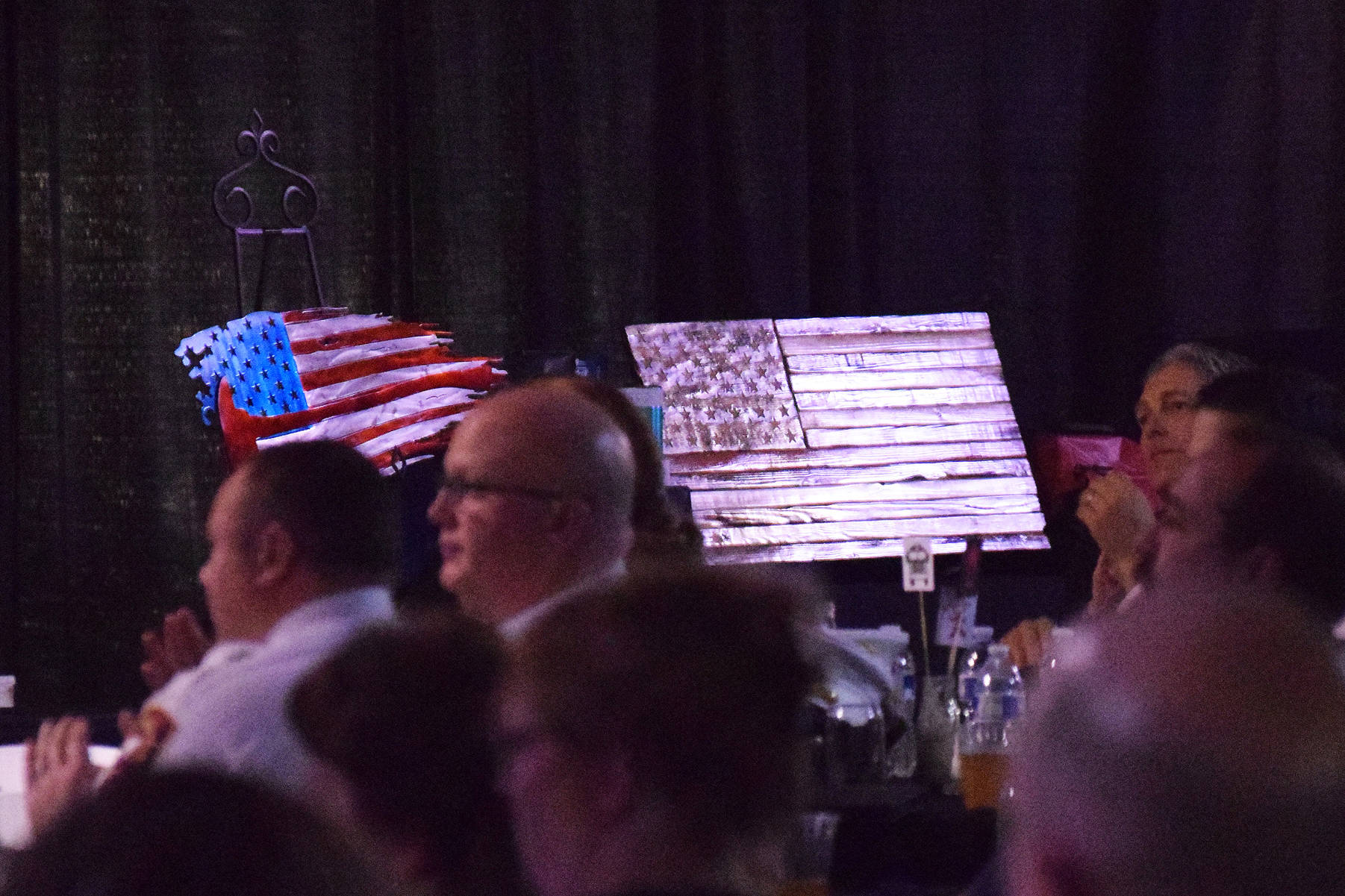 A pair of American flag design wall plaques sit on stage Friday night at the Alaska Fire Conference in the Kenai Center mall. (Photo by Joey Klecka/Peninsula Clarion)