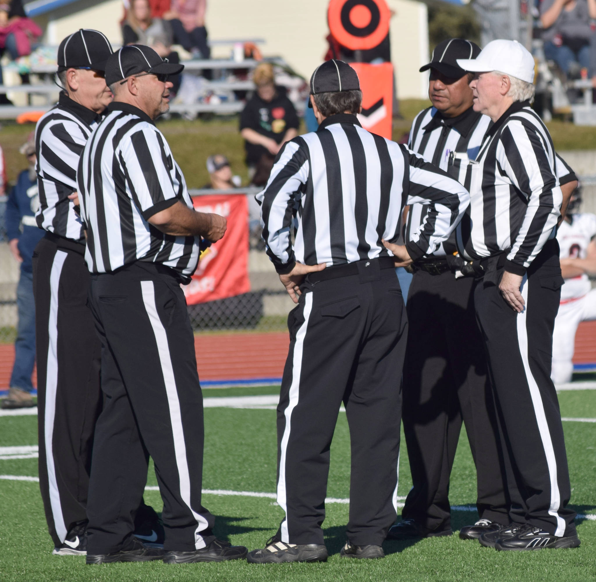 Randy Sparks, far right, confers with his officiating crew Saturday, Sept. 29, 2018, during the Soldotna-Kenai Central game at Justin Maile Field in Soldotna. After 22 years, Sparks was officiating his late game on the Kenai Peninsula. (Photo by Jeff Helminiak/Peninsula Clarion)