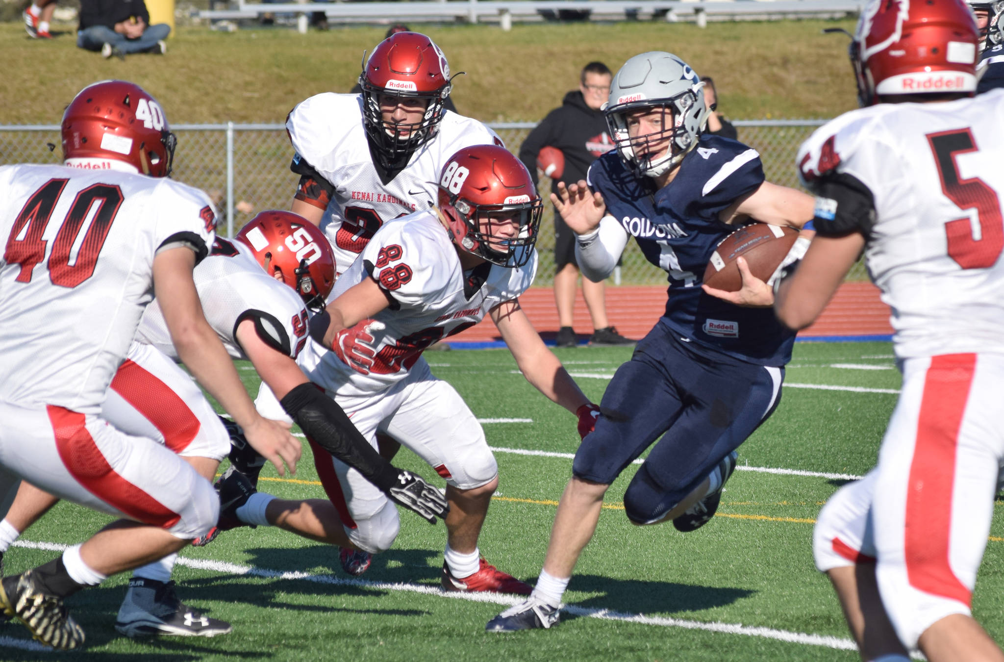 Soldotna quarterback Jersey Truesdell tries to elude Kenai Central defenders Justin Anderson, Billy Morrow, Tucker Vann, Braedon PItsch and Jacob Howard on Saturday at Justin Maile Field in Soldotna. (Photo by Jeff Helminiak/Peninsula Clarion)