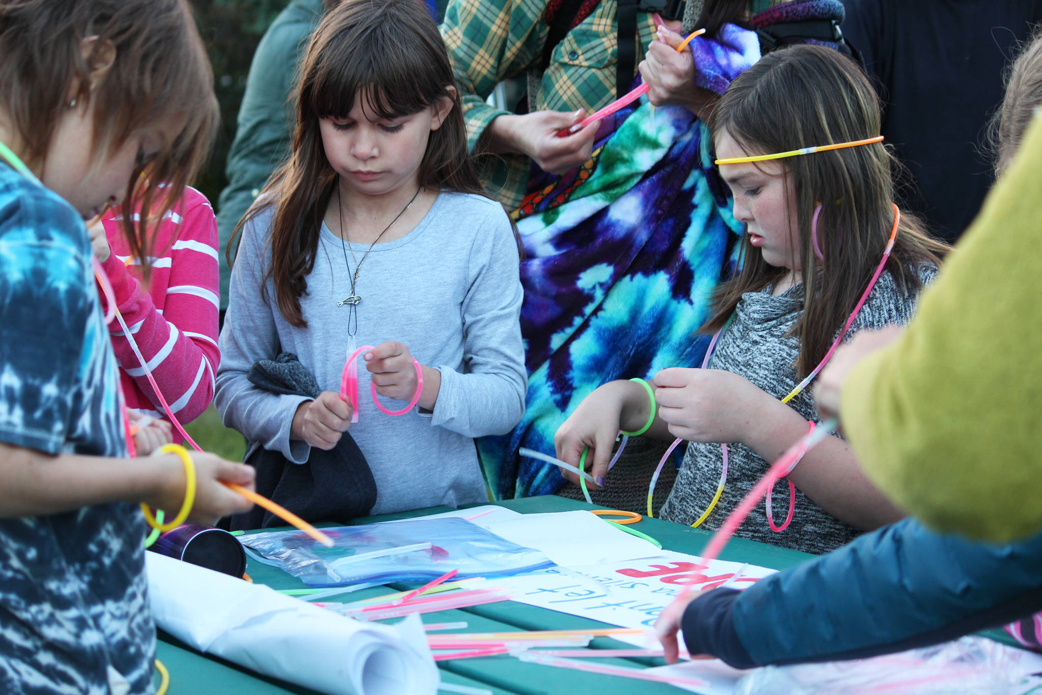 Children prepare glow sticks to walks with before a Light the Night march Saturday, Sept. 29, 2018 at WKFL Park in Homer, Alaska. (Photo by Megan Pacer/Homer News)