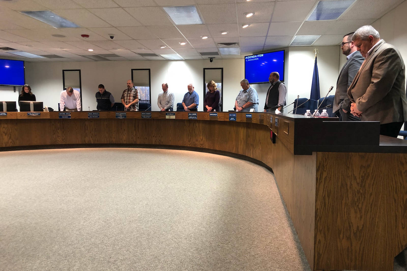 Members of the Kenai Peninsula Borough Assembly hold a religious invocation during Tuesday night’s assembly meeting in Soldotna. The invocation was held only hours after the Alaska Superior Court ruled the ritual violated the Alaska Constitution. (Photo by Victoria Petersen/Peninsula Clarion)