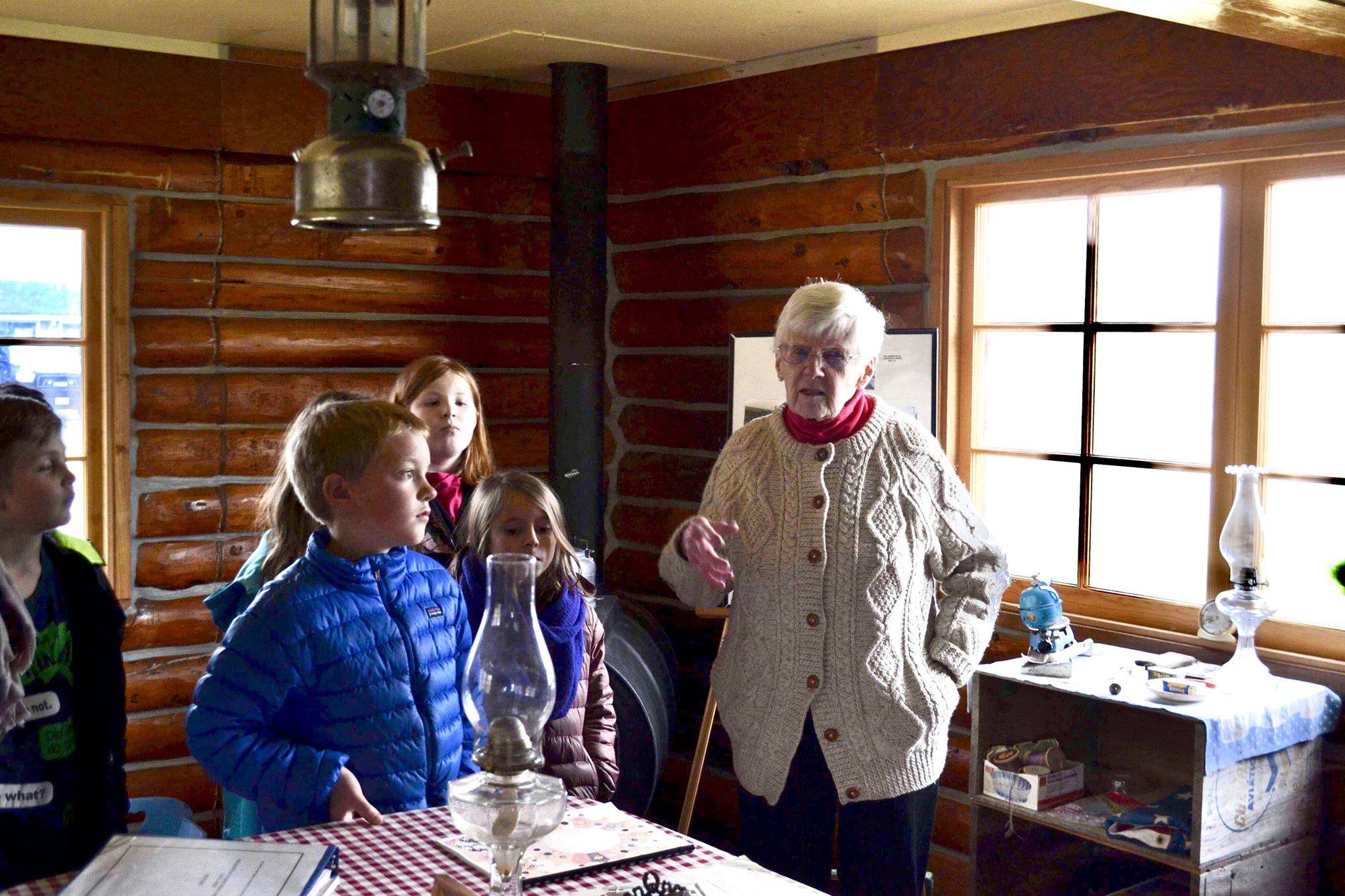 Marge Mullen shows a group of third graders around the Howard Lee Homestead, which was used as the city’s first post office when she first homesteaded in Soldotna, on Wednesday, oct. 17, 2018, in Soldotna, AK. (Photo by Victoria Petersen/Peninsula Clarion)