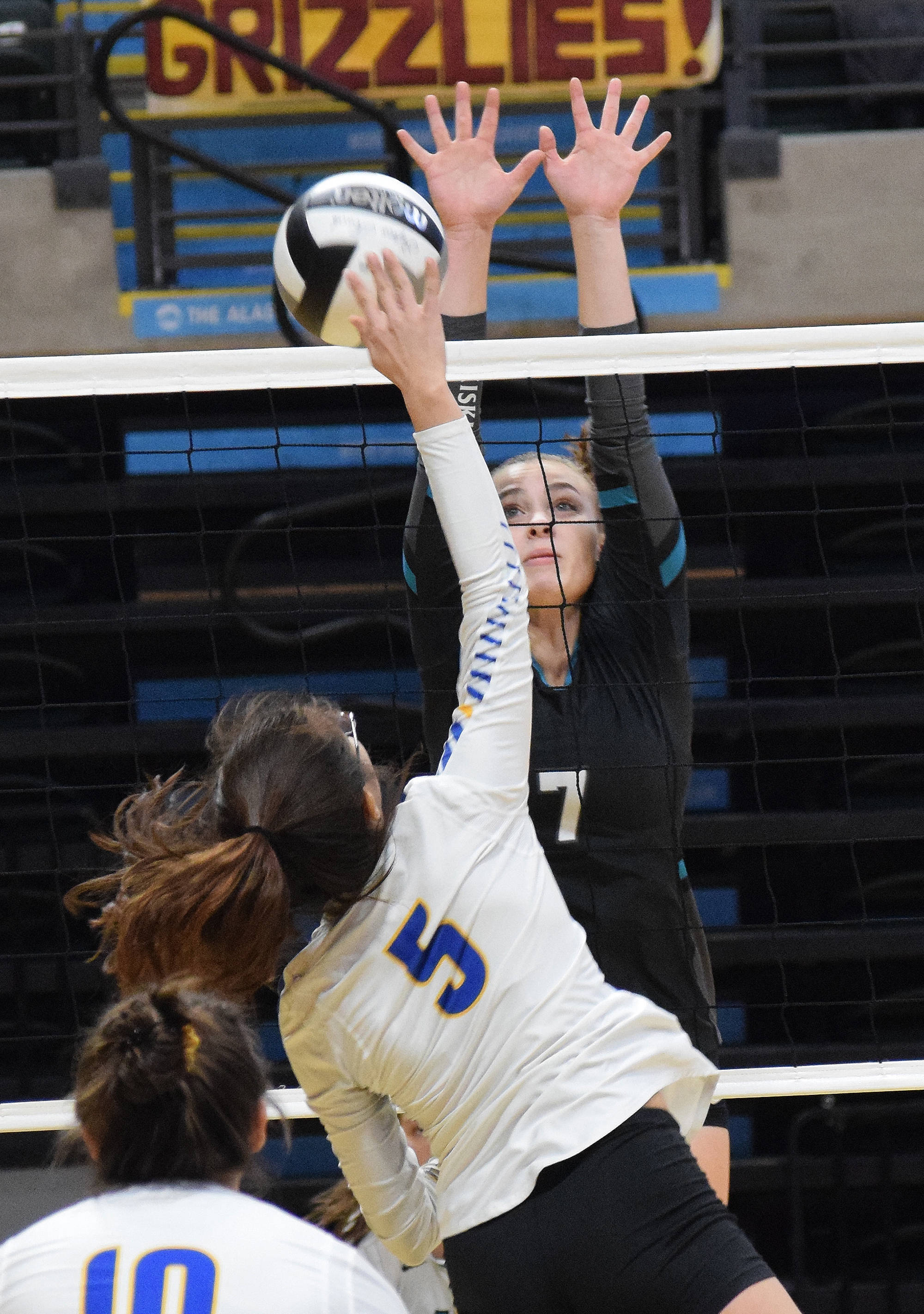 Nikiski’s Bethany Carstens blocks a shot by Barrow’s Jillian Chrestman-Adams (5) Thursday at the Class 3A state volleyball tournament at the Alaska Airlines Center. (Photo by Joey Klecka/Peninsula Clarion)