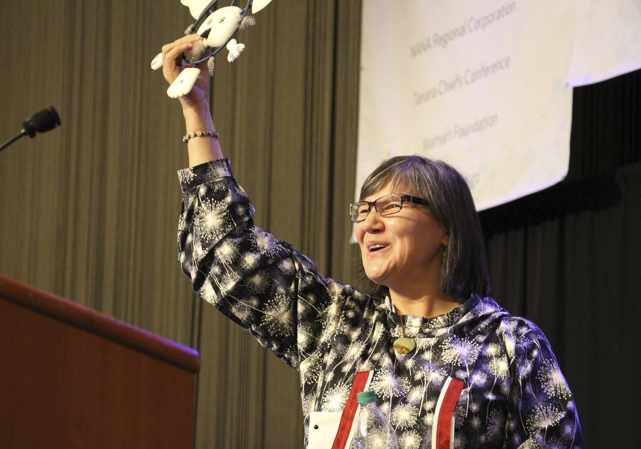 Alaska Lt. Gov. Valerie Davidson holds up an owl mask presented to her after addressing delegates at the annual Alaska Federation of Natives conference in Anchorage, Alaska, on Thursday, Oct. 18, 2018. Davidson was sworn in as lieutenant governor on Oct. 16, 2018, after Bryon Mallott resigned. (AP Photo/Mark Thiessen)