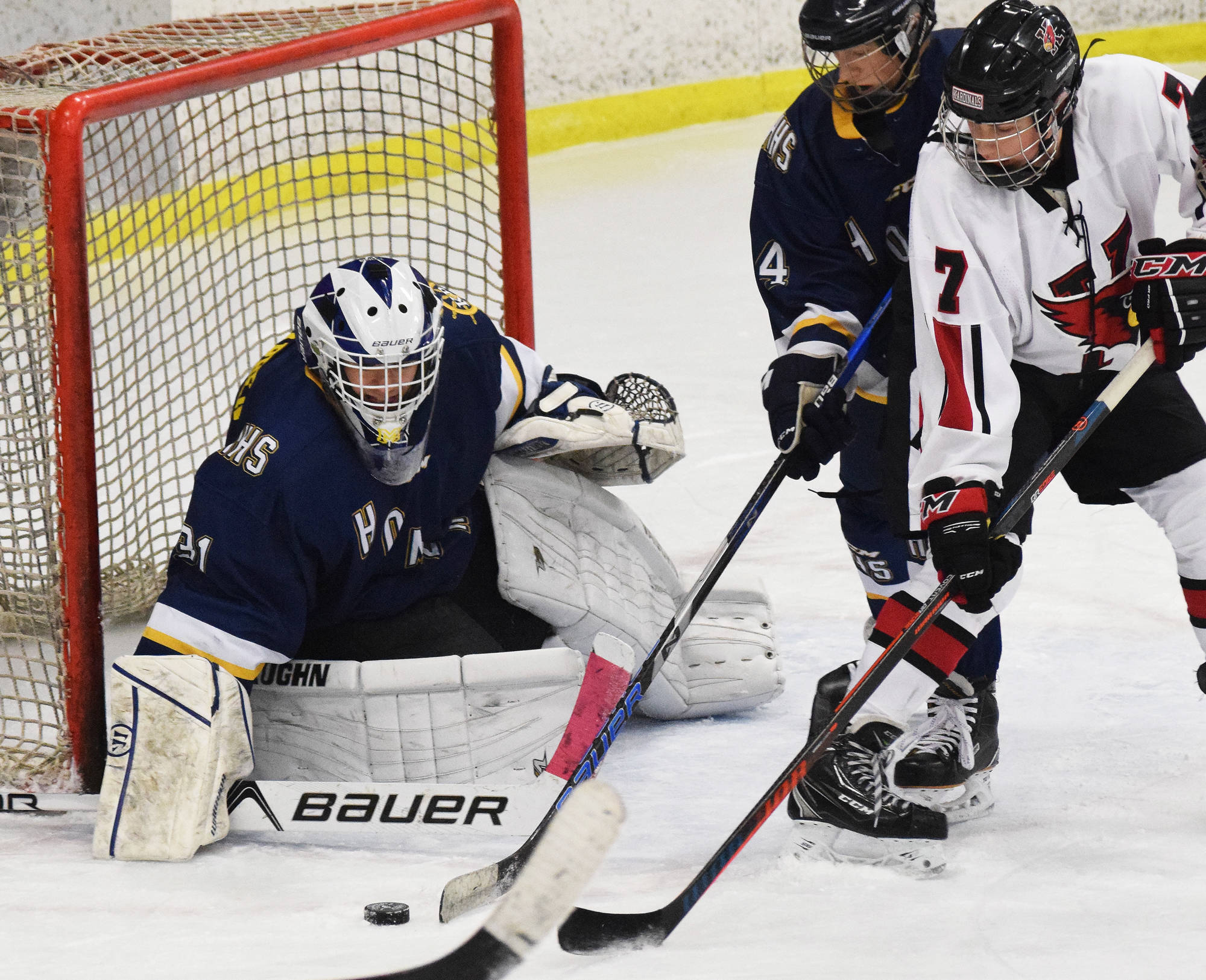 Homer goaltender Hunter Warren wards off a shot from Kenai skater Jacob Begich (7) Tuesday night at the Kenai Multi Purpose Facility. (Photo by Joey Klecka/Peninsula Clarion)