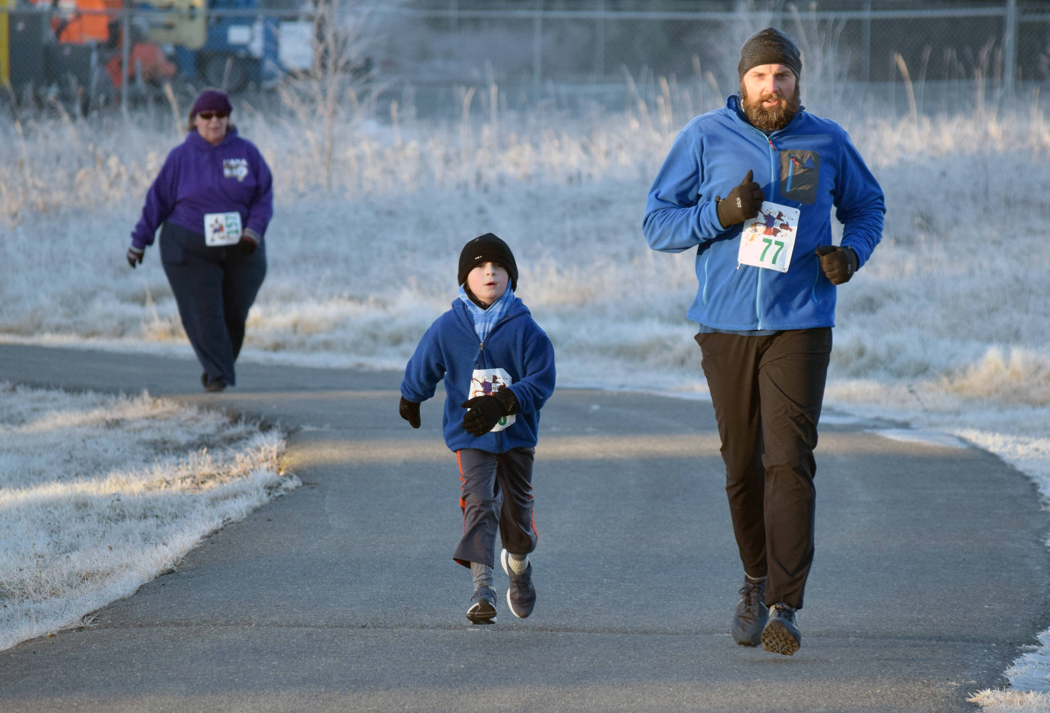 Hans Schlegel, 40, of Soldotna and his son Benjamin near the end of the three-mile race at the Turkey Trot at the Soldotna Regional Sports Complex on Thursday, Nov. 22, 2018. (Photo by Jeff Helminiak/Peninsula Clarion)