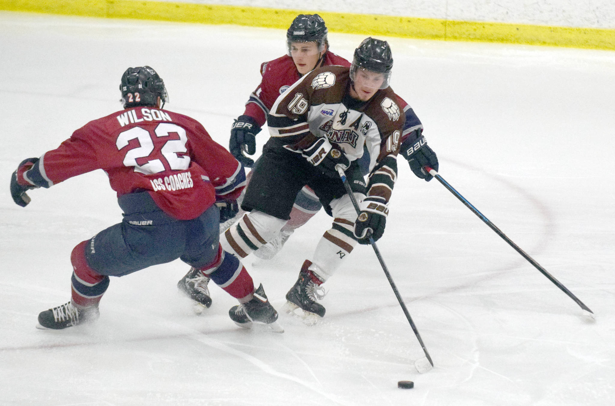 Kenai River Brown Bears forward Michael Spethmann tries to squeeze between Noah Wilson and Luke Ciolli of the Fairbanks Ice Dogs on Friday, Nov. 23, 2018, at the Soldotna Regional Sports Complex. (Photo by Jeff Helminiak/Peninsula Clarion)