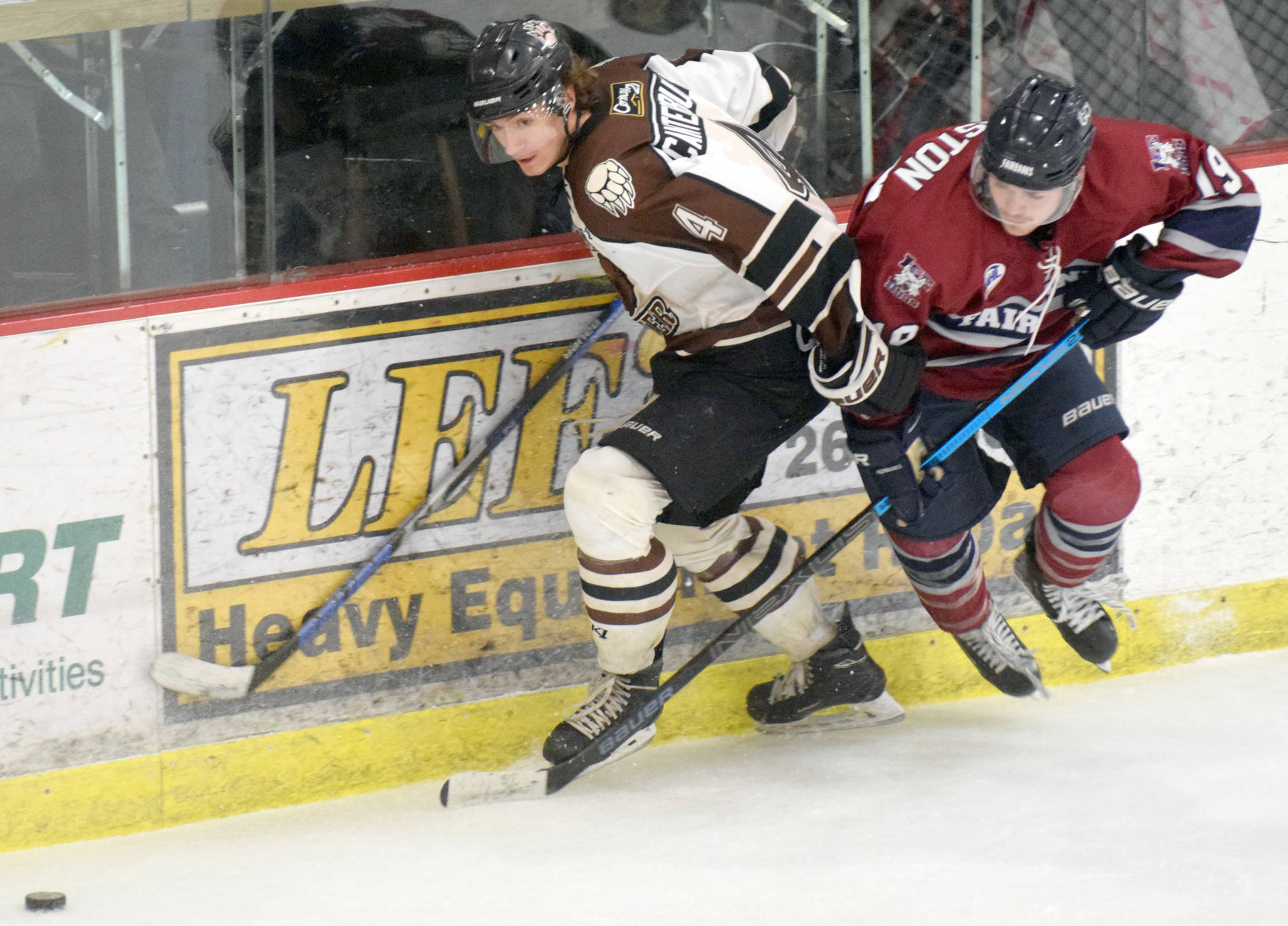 Kenai River Brown Bears defenseman Connor Canterbury and Fairbanks Ice Dogs forward Jack Johnston battle for the puck Sunday, Nov. 25, 2018, at the Soldotna Regional Sports Complex. (Photo by Jeff Helminiak/Peninsula Clarion)