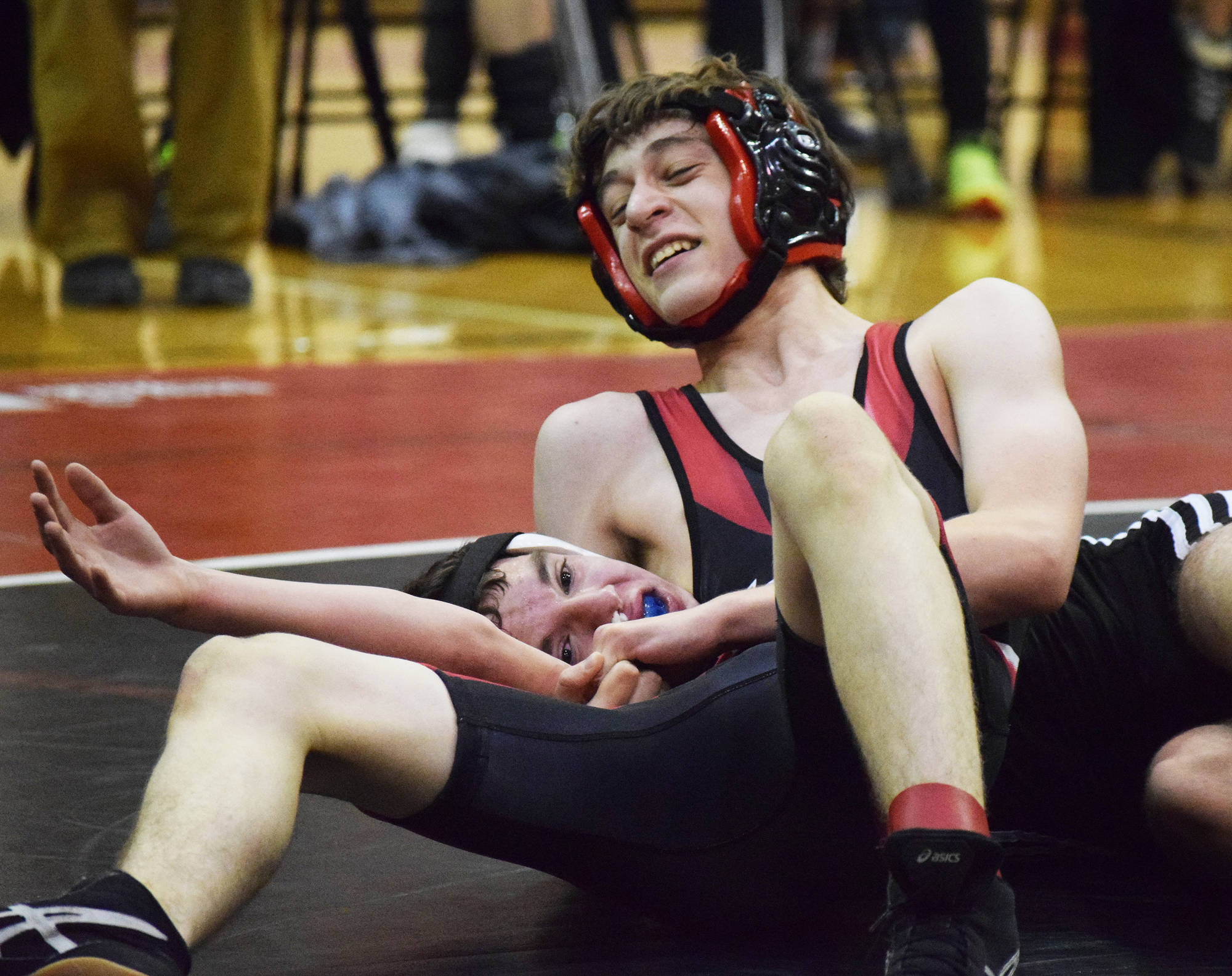 Kenai’s Daemon Duniphin (top) puts Nikiski’s Joey Yourkoski in a chokehold Tuesday night in a dual meet at Kenai Central High School. (Photo by Joey Klecka/Peninsula Clarion)