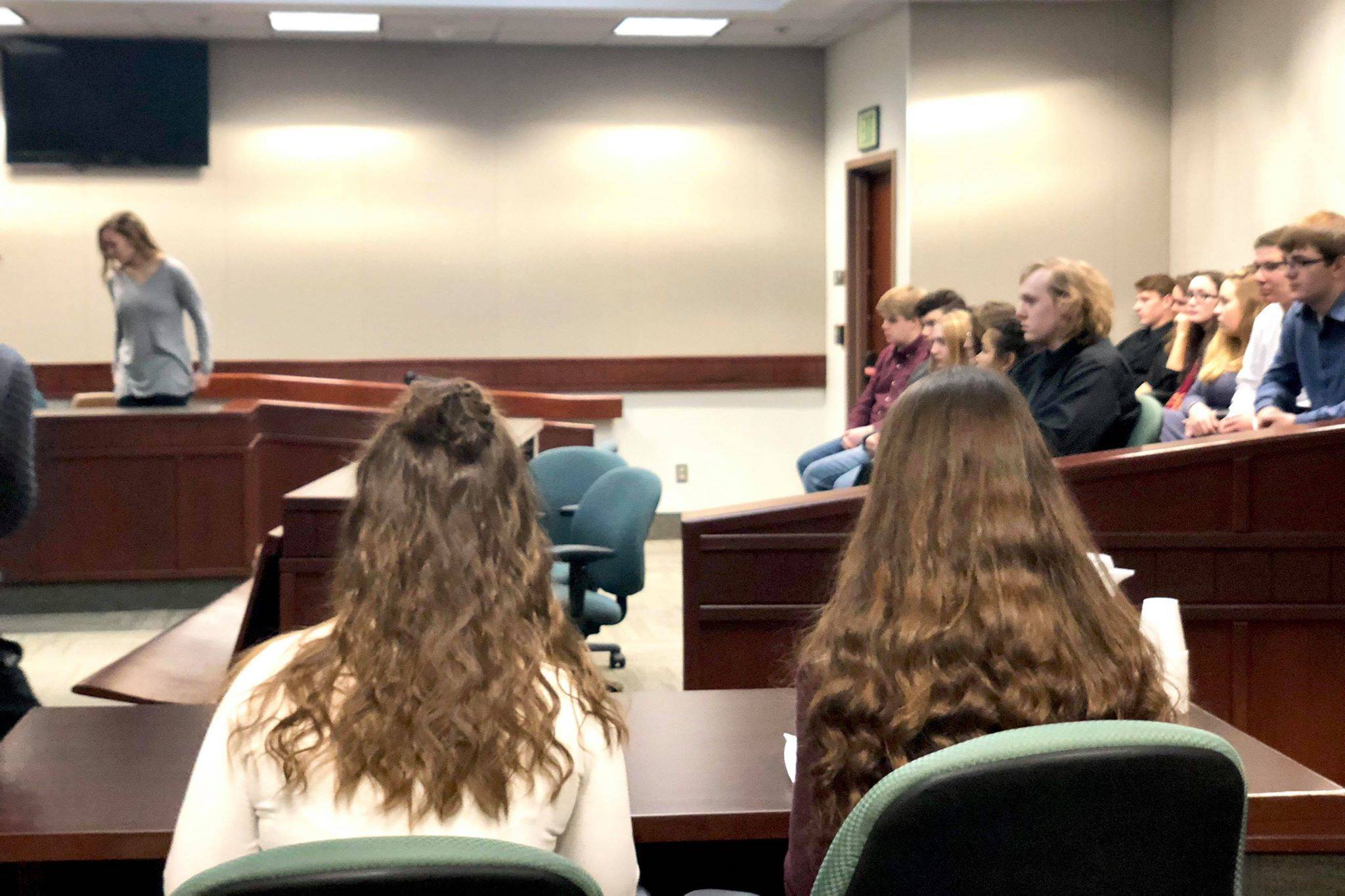 Mock defense attorneys, Emma Wik and Kelsey Clark, sit and wait while a witness is questioned during Nikiski High’s mock trial event on Thursday at the Kenai Courthouse. (Photo by Victoria Petersen/Peninsula Clarion)