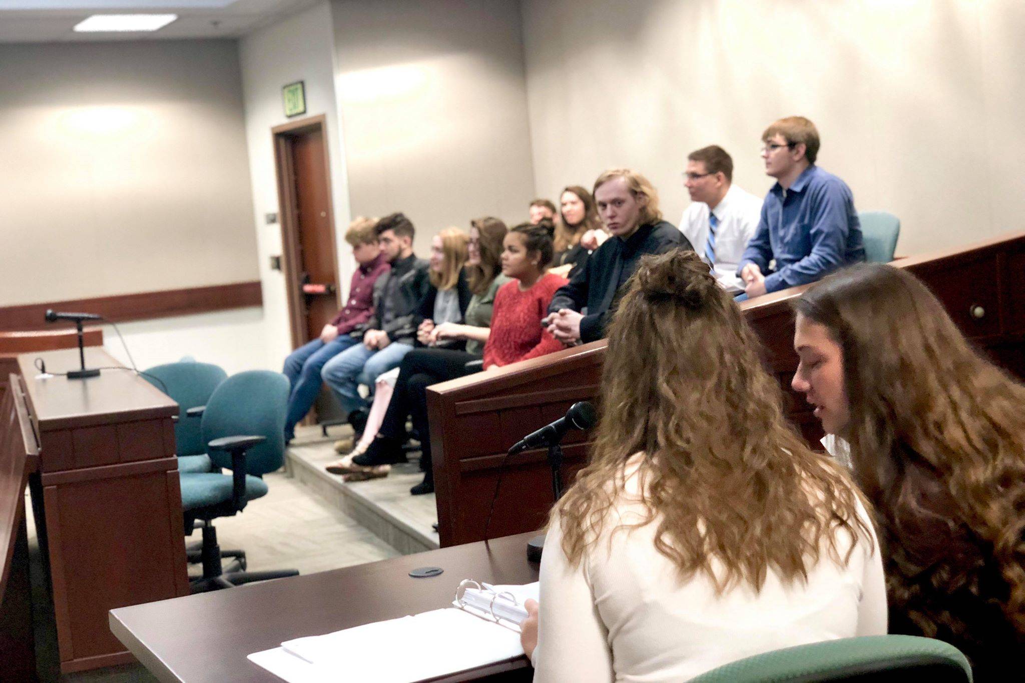 Mock defense attorneys, Emma Wik and Kelsey Clark discuss their client during Nikiski High’s mock trial event on Thursday at the Kenai Courthouse. (Photo by Victoria Petersen/Peninsula Clarion)