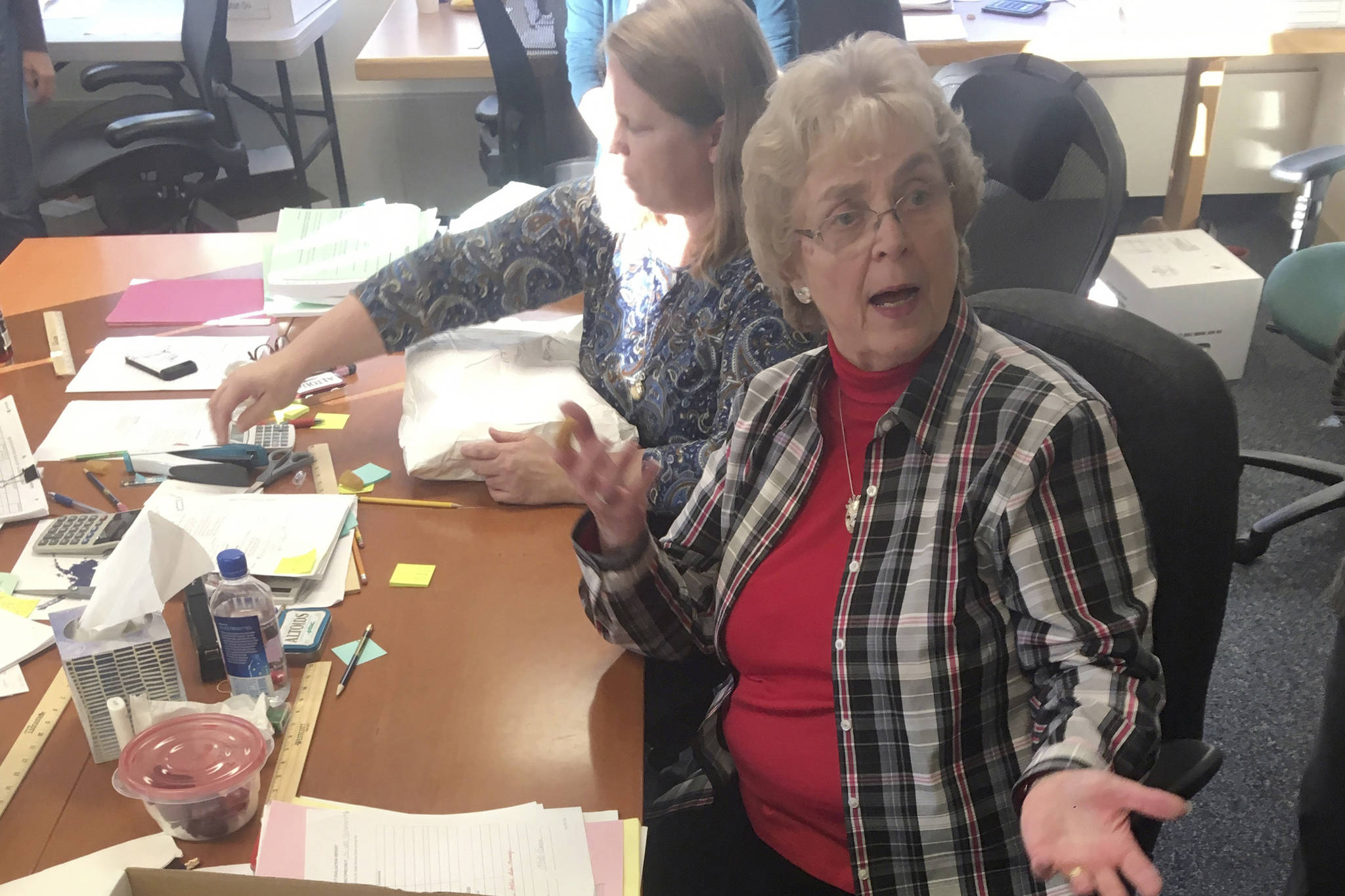 This Nov. 23, 2018 photo shows Alaska State Review Board ballot examiner Stuart Sliter reacting when a loose ballot from a tied state House race is found without an envelope in Juneau, Alaska. Officials are investigating the origin of the ballot and will decide by Friday, Nov. 30, whether to count it during a recount of the Fairbanks House District 1 race. (James Brooks/Anchorage Daily News via AP)