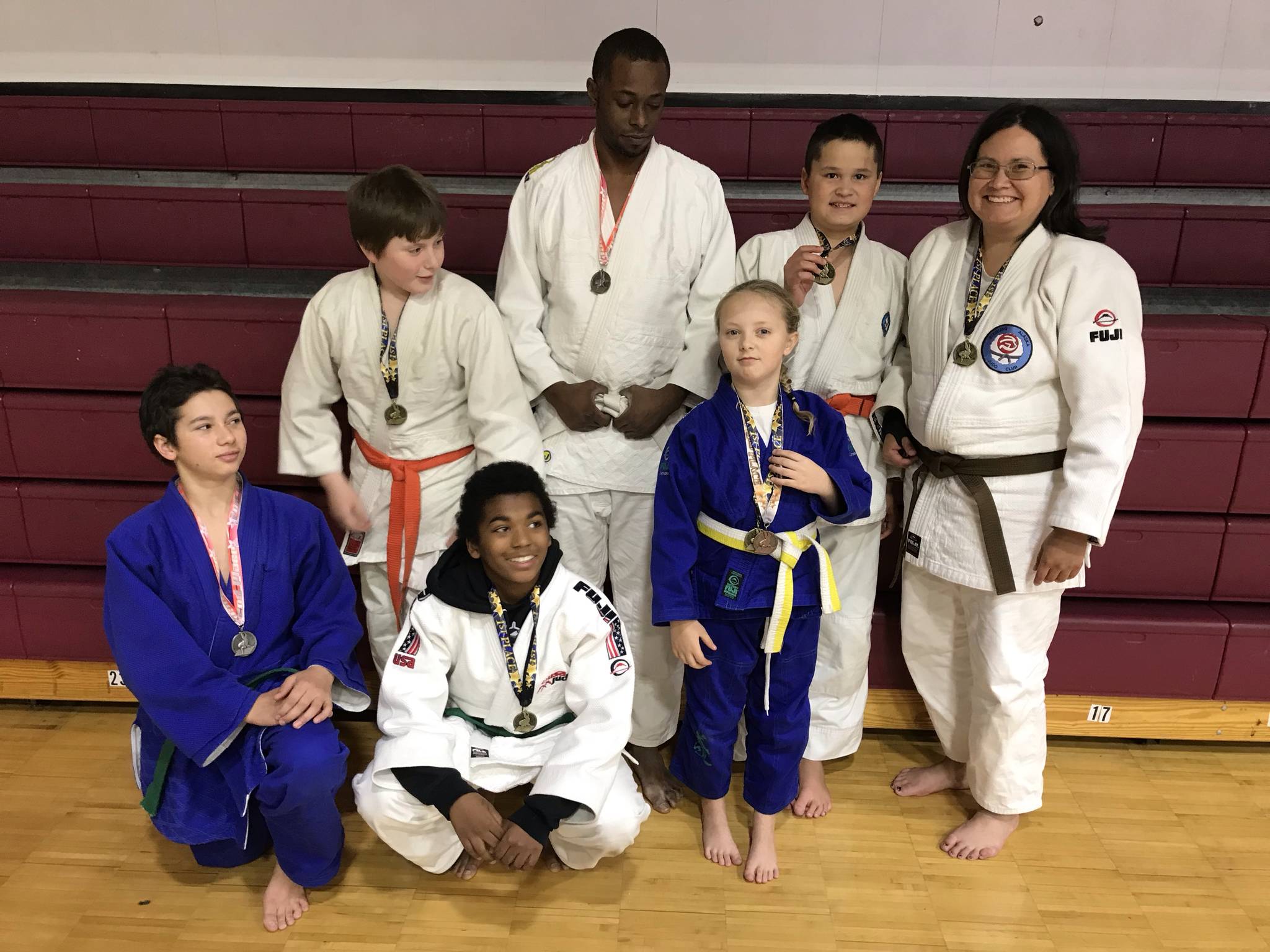 Kenai Peninsula judo fighters show off their medals. In front: Charles Fairbanks, Elijah Lee and unnamed competitor from another club; Back row: Liam Way, Maurice Green, Axel Coxwell and Stephanie Coxwell.(Photo submitted by Robert Brink)