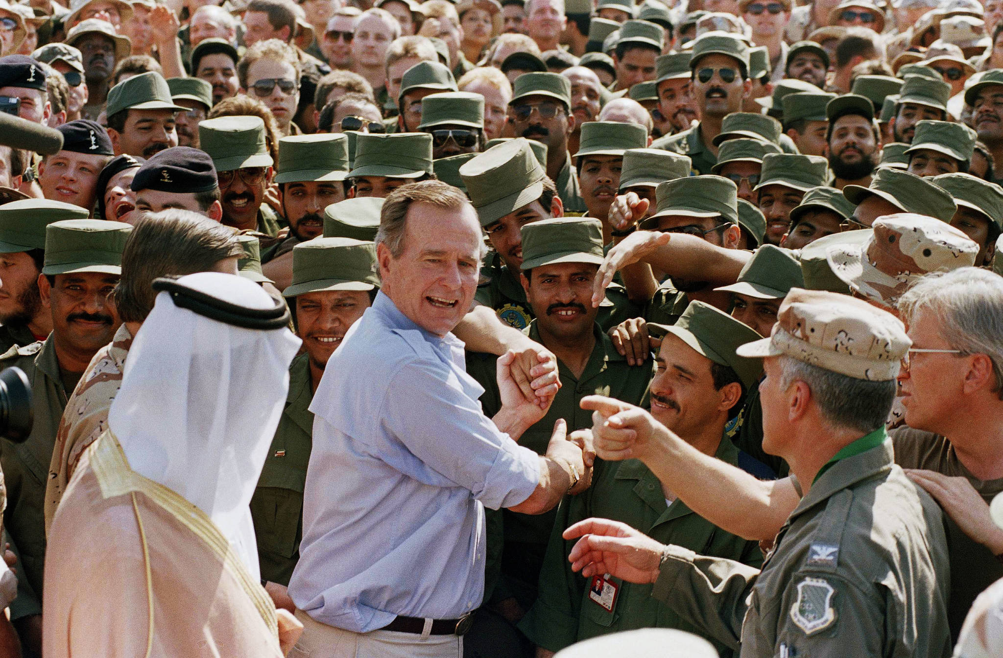 In this Nov. 22, 1990 file photo, President George H.W. Bush is greeted by Saudi troops and others as he arrives in Dhahran, Saudi Arabia, for a Thanksgiving visit. Bush died at the age of 94 on Friday, about eight months after the death of his wife, Barbara Bush. (AP Photo/J. Scott Applewhite, File)
