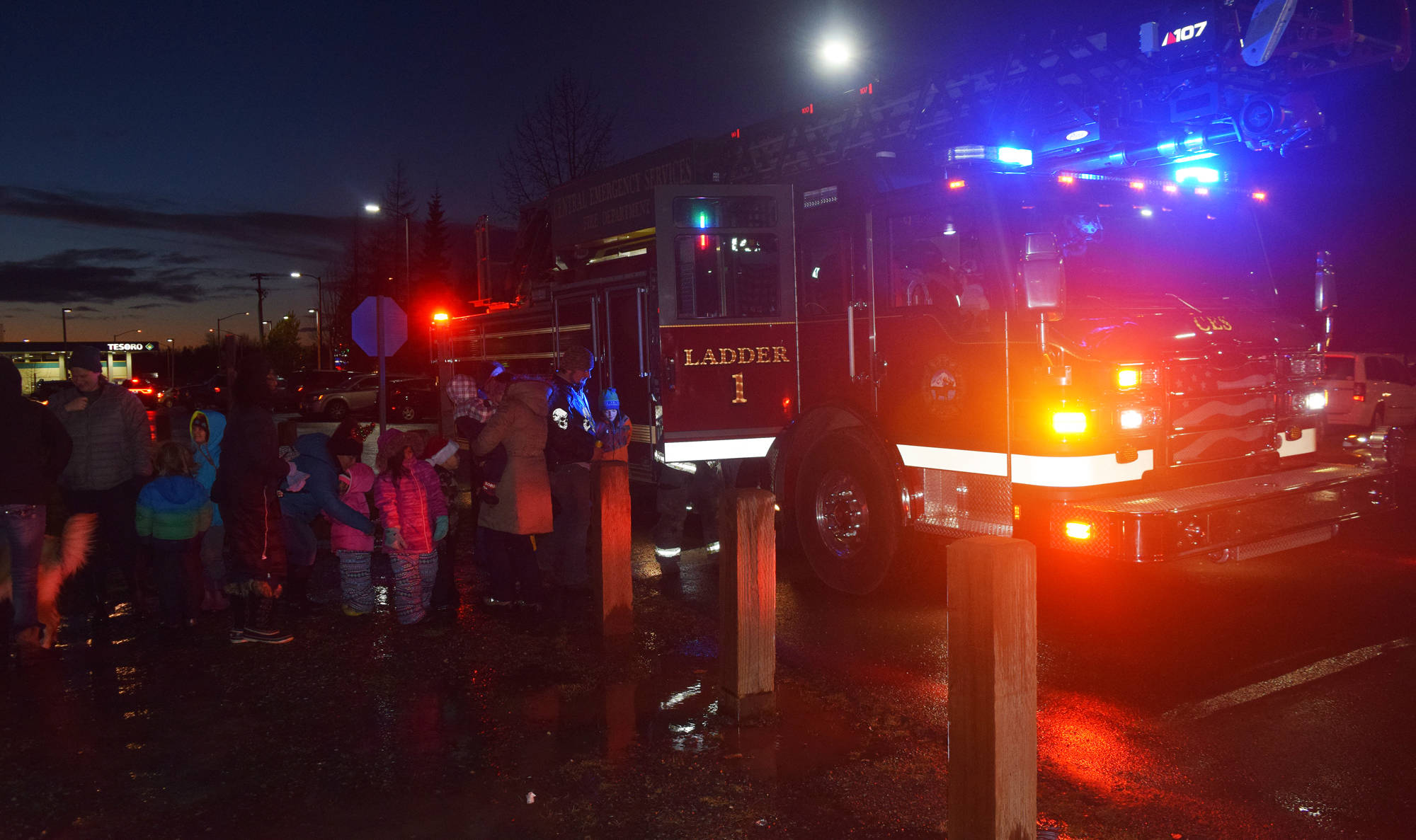 Firefighters from Central Emergency Services take visitors on a tour of their fire truck Saturday, Dec. 1 at the Christmas in the Park tree-lighting ceremony at Soldotna Creek Park, in Soldotna, Alaska. (Photo by Joey Klecka/Peninsula Clarion)