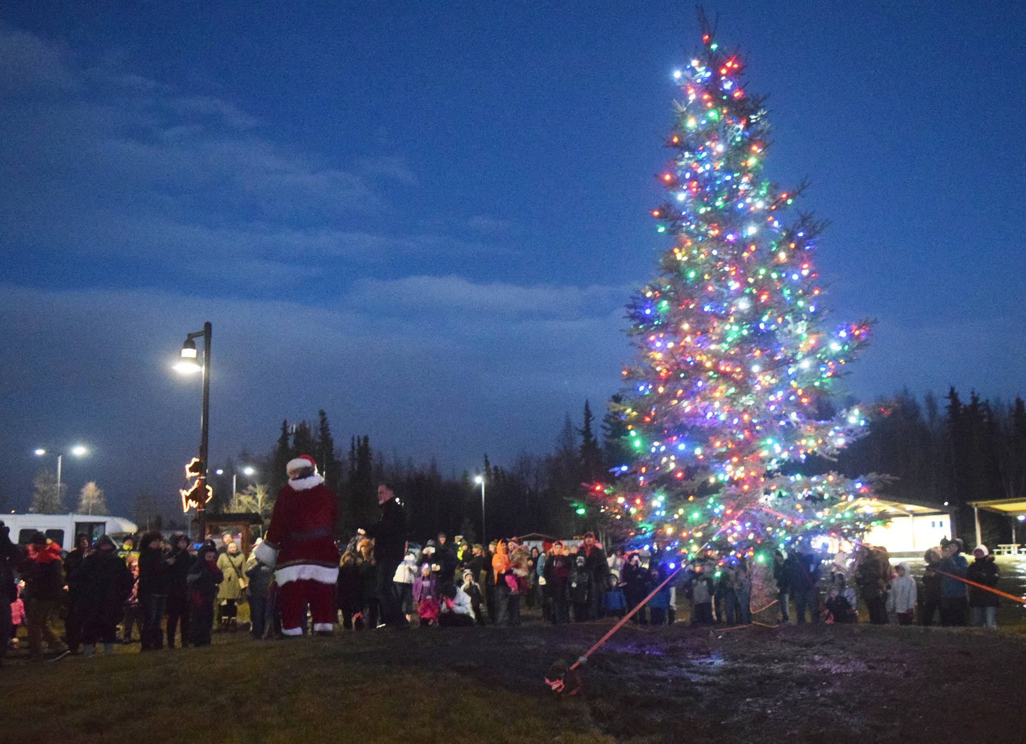 A crowd watches as Santa Claus turns on the lights adorning the Christmas tree Saturday, Dec. 1 at the Christmas in the Park tree-lighting ceremony at Soldotna Creek Park, in Soldotna, Alaska. (Photo by Joey Klecka/Peninsula Clarion)