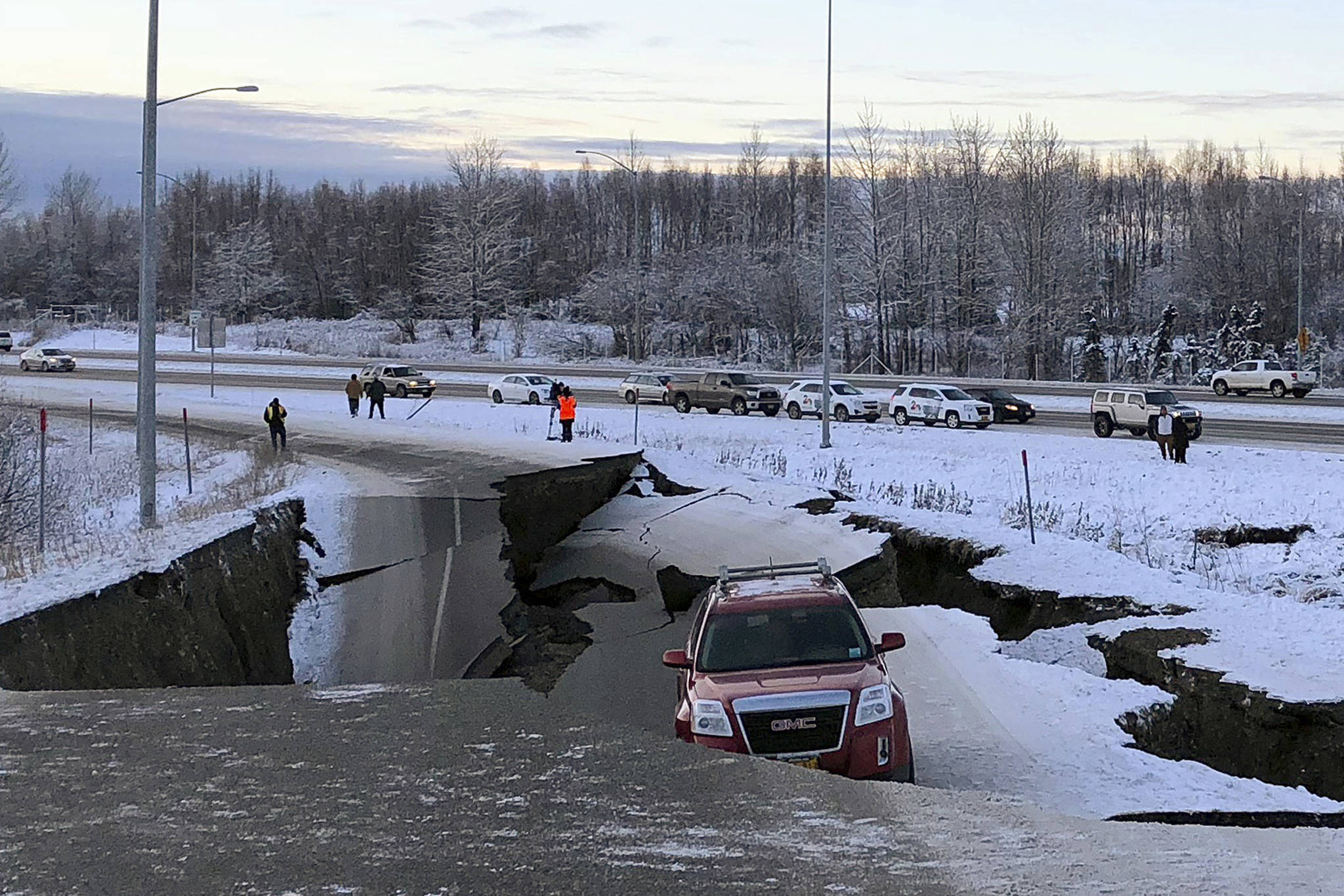 A car belonging to Homer resident Tom Sulczynski is trapped on a collapsed section of the offramp of Minnesota Drive in Anchorage, Friday, Nov. 30, 2018. Sulczynski and passenger Bekah Taylor escaped the car without injury. Back-to-back earthquakes measuring 7.0 and 5.8 rocked buildings and buckled roads Friday morning in Anchorage, prompting people to run from their offices or seek shelter under office desks, while a tsunami warning had some seeking higher ground. (AP Photo/Dan Joling)