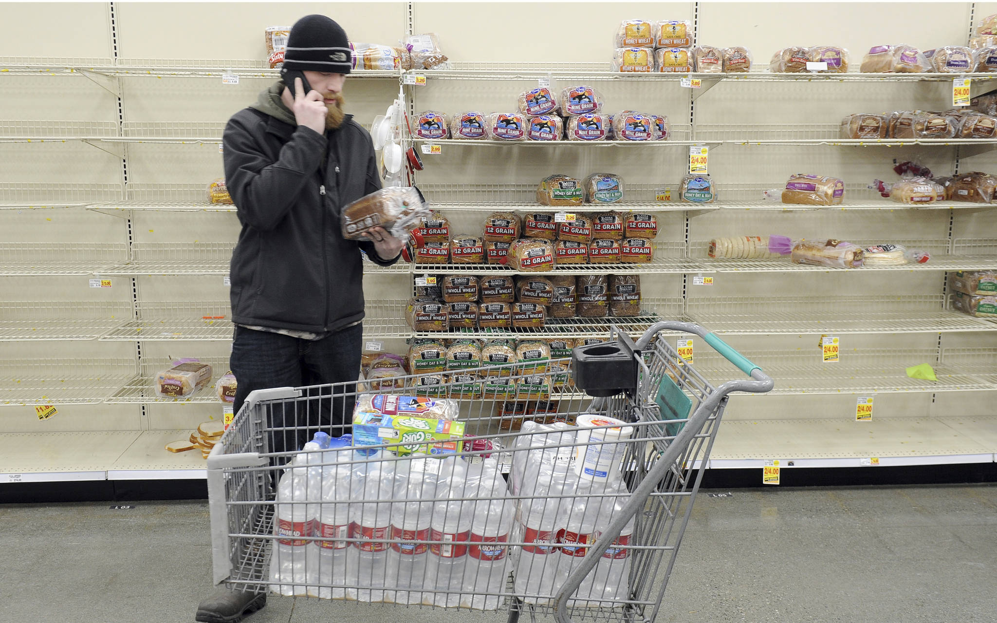 Anchorage resident C.J. Johnson stocks up on water and bread at a local grocery, after the morning’s 7.0-magnitude earthquake which caused extensive damage to the local area in Anchorage, Alaska, Friday, Nov. 30, 2018. The earthquake that shook Anchorage and damaged roadways also knocked many traffic lights out of service and has snarled traffic. (AP Photo/Michael Dinneen)