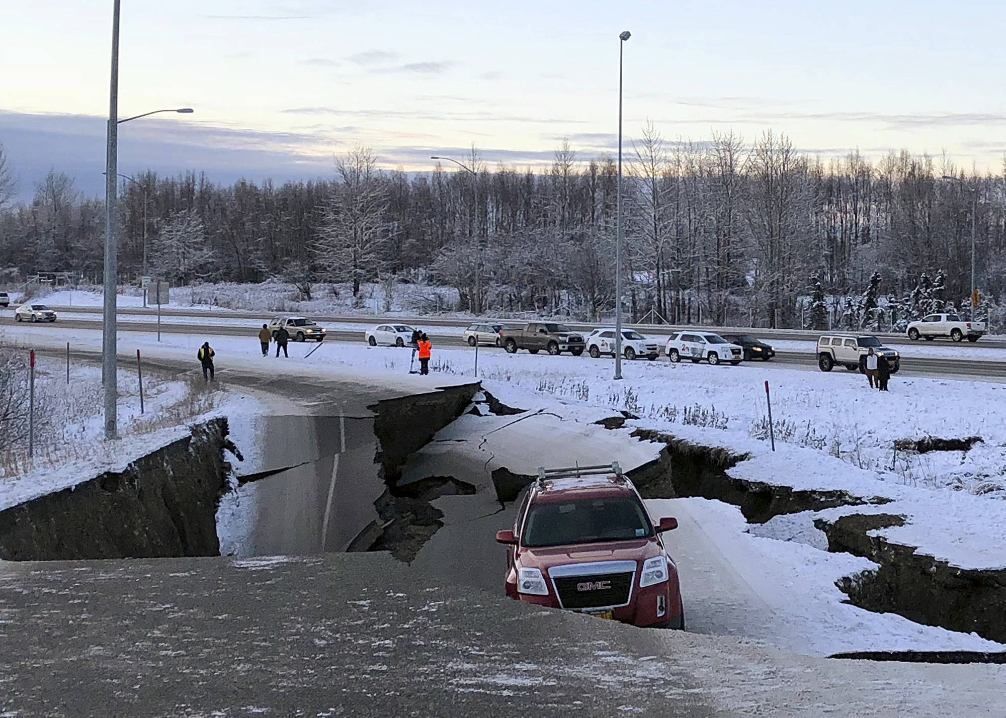A car is trapped on a collapsed section of the offramp of Minnesota Drive in Anchorage, Friday, Nov. 30, 2018. Back-to-back earthquakes measuring 7.0 and 5.8 rocked buildings and buckled roads Friday morning in Anchorage, prompting people to run from their offices or seek shelter under office desks, while a tsunami warning had some seeking higher ground. (AP Photo/Dan Joling)