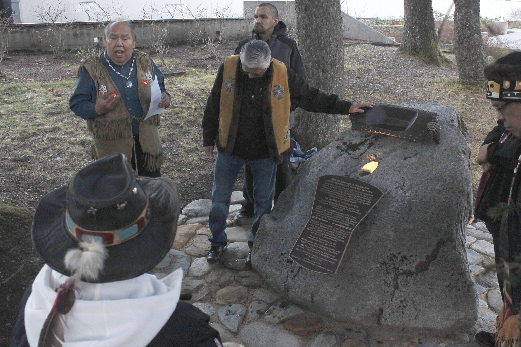 In this Nov. 23, 2018 photo, Tlingit elders David Katzeek, left, and Paul Marks present the Sayéik Sacred Site Memorial in Juneau, Alaska. The memorial, placed at Sayéik Gastineau Community School, is a tribute to the people who were buried in the Tlingit burial ground that was paved over for the road and school. (Alex McCarthy/The Juneau Empire via AP)