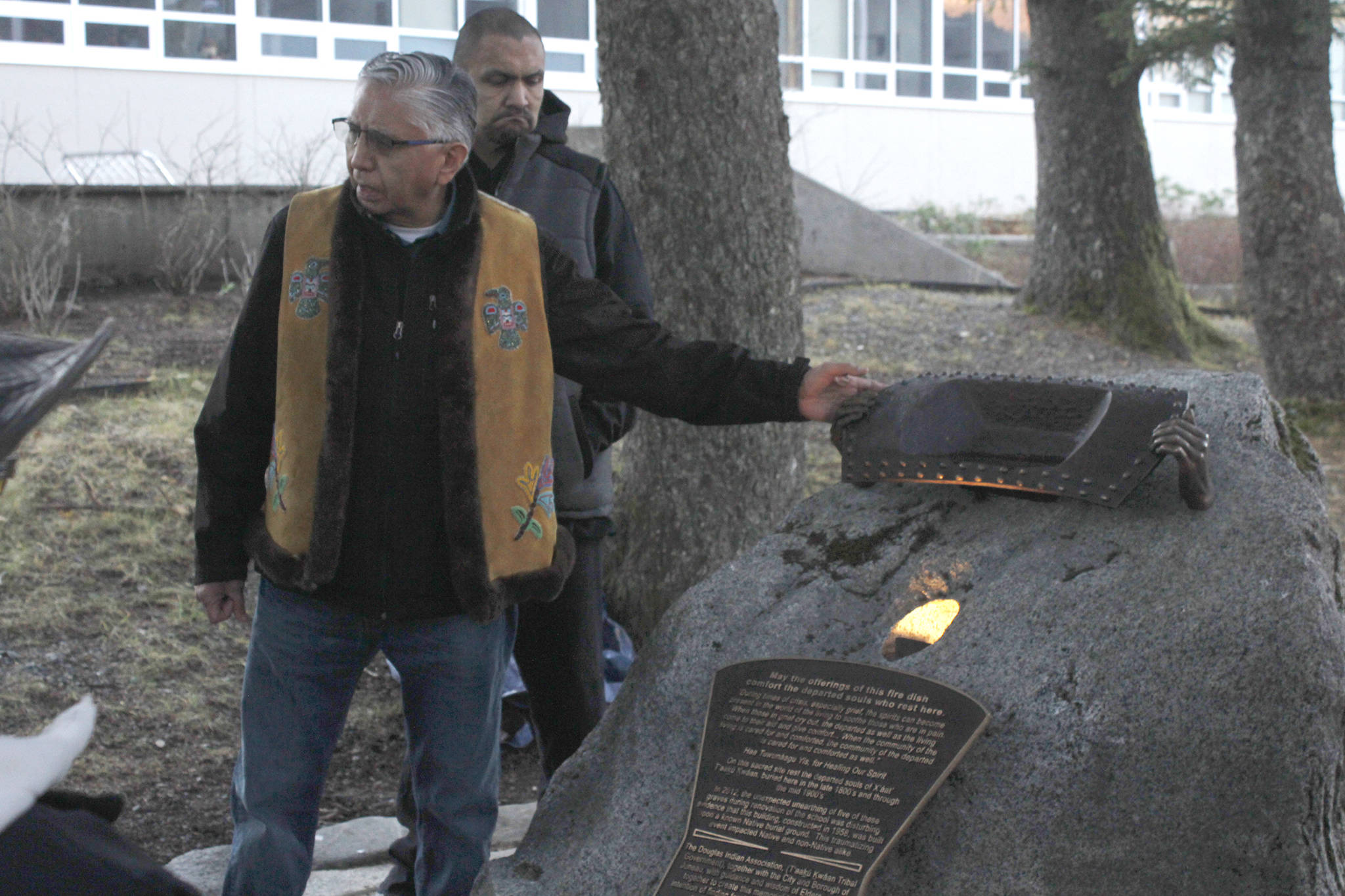 In this photo taken Nov. 23, 2018, Tlingit elder Paul Marks presents the Sayéik Sacred Site Memorial in Juneau, Alaska. The memorial, placed at Sayéik Gastineau Community School, is a tribute to the people who were buried in the Tlingit burial ground that was paved over for the road and school. (Alex McCarthy/The Juneau Empire via AP)