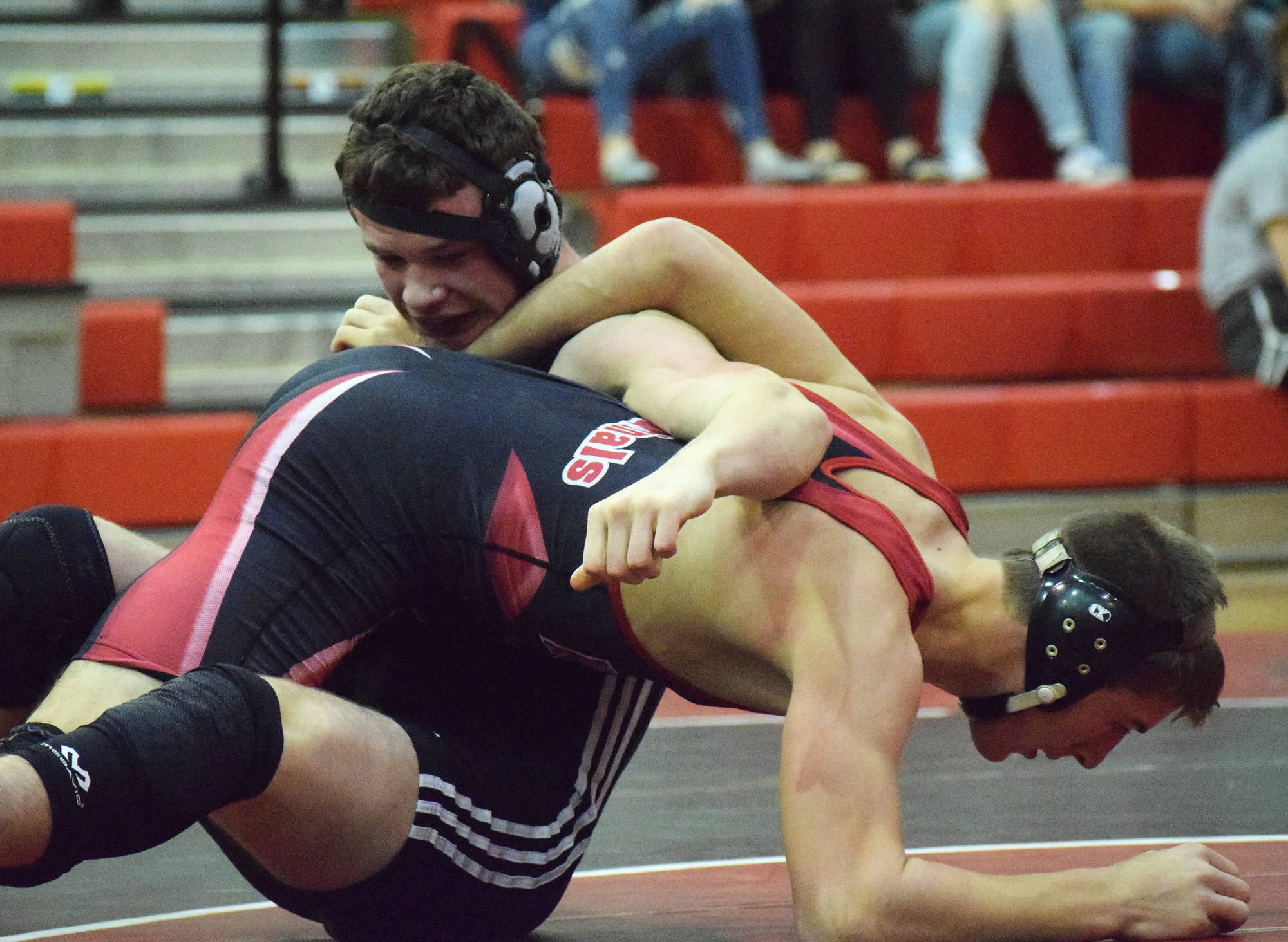 Nikiski’s Koleman McCaughey (top) wrestles with Kenai’s Tucker Vann in a dual meet Nov. 27, 2018, at Kenai Central High School. (Photo by Joey Klecka/Peninsula Clarion)