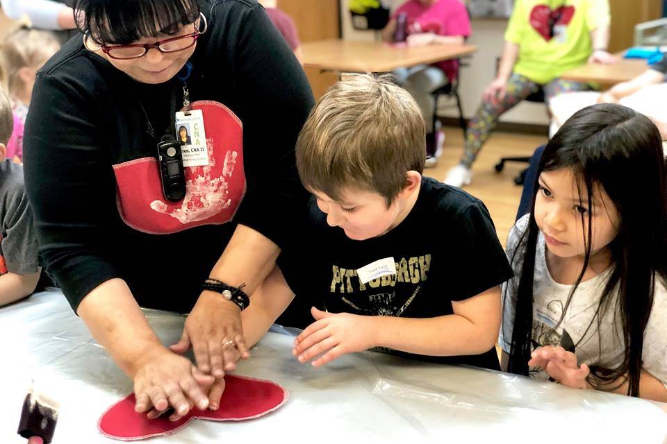 Residents from Heritage Place help kindergartner students make Dignity Mission T-shirts during a visit on Friday, Dec. 7, 2018, in Soldotna, Alaska. (Photo by Victoria Petersen/Peninsula Clarion)