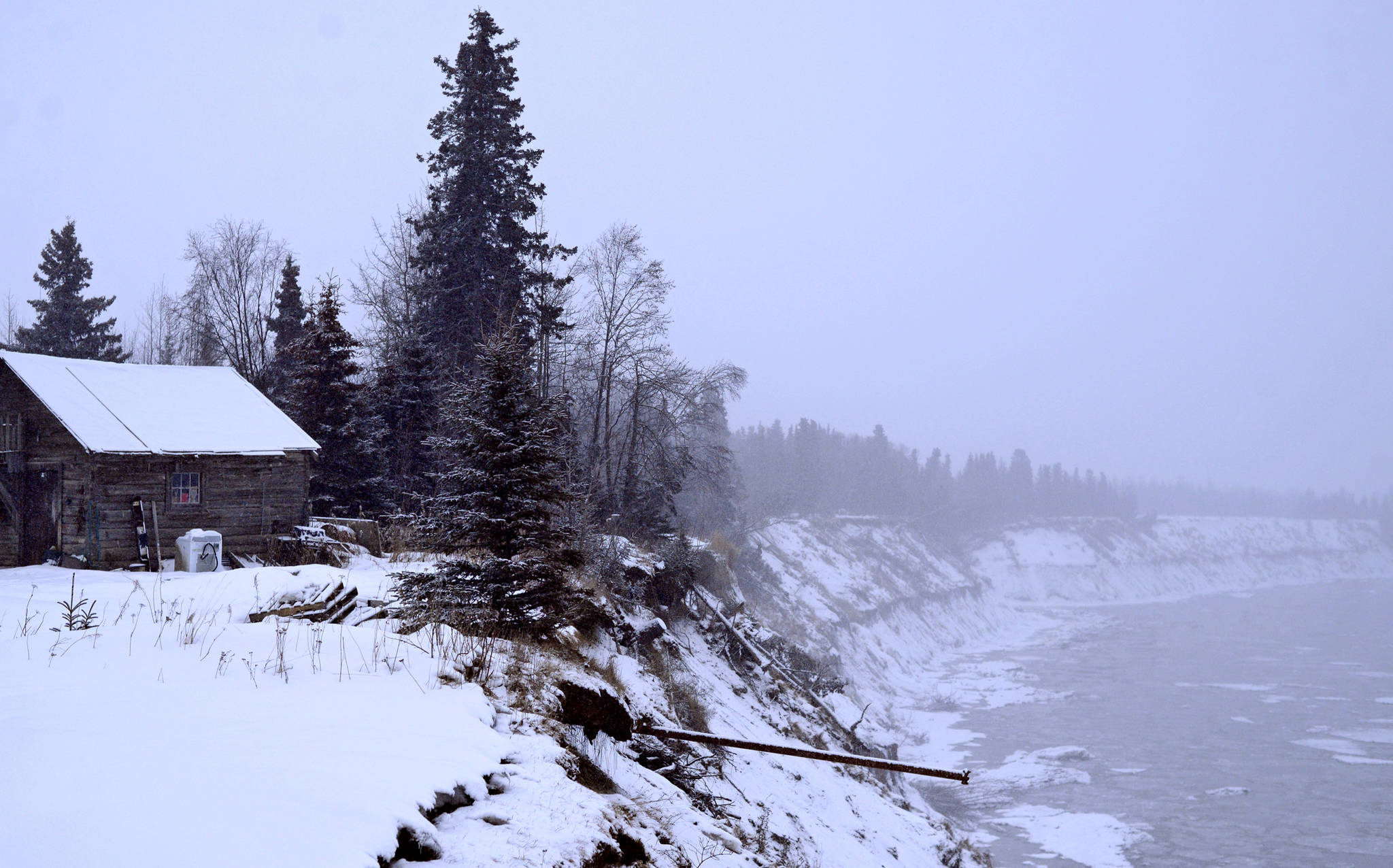 A building stands close to the edge of the Kenai River bluffs in February 2017. The bluffs are eroding at roughly 3 feet per year. (Ben Boettger/Peninsula Clarion file photo)