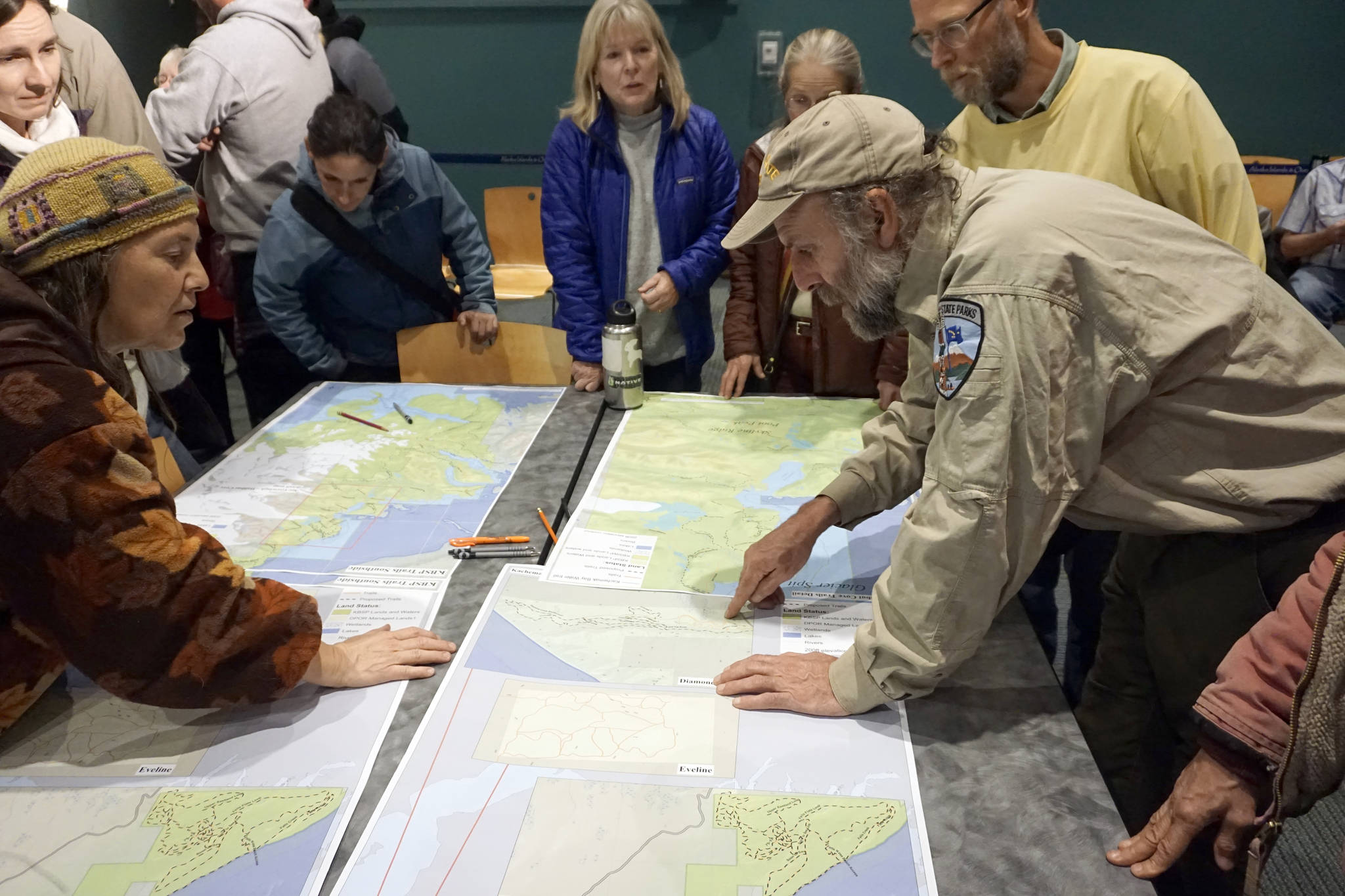 Laurie Daniel, left, and Alaska State Parks specialist Eric Clarke, right, discuss the Diamond Creek trails portion of the Kachemak Bay State Park and State Wilderness Park draft management plan at an open house on the plan on Oct. 29, 2018, at the Alaska Islands and Ocean Visitor Center in Homer, Alaska. (Photo by Michael Armstrong/Homer News)
