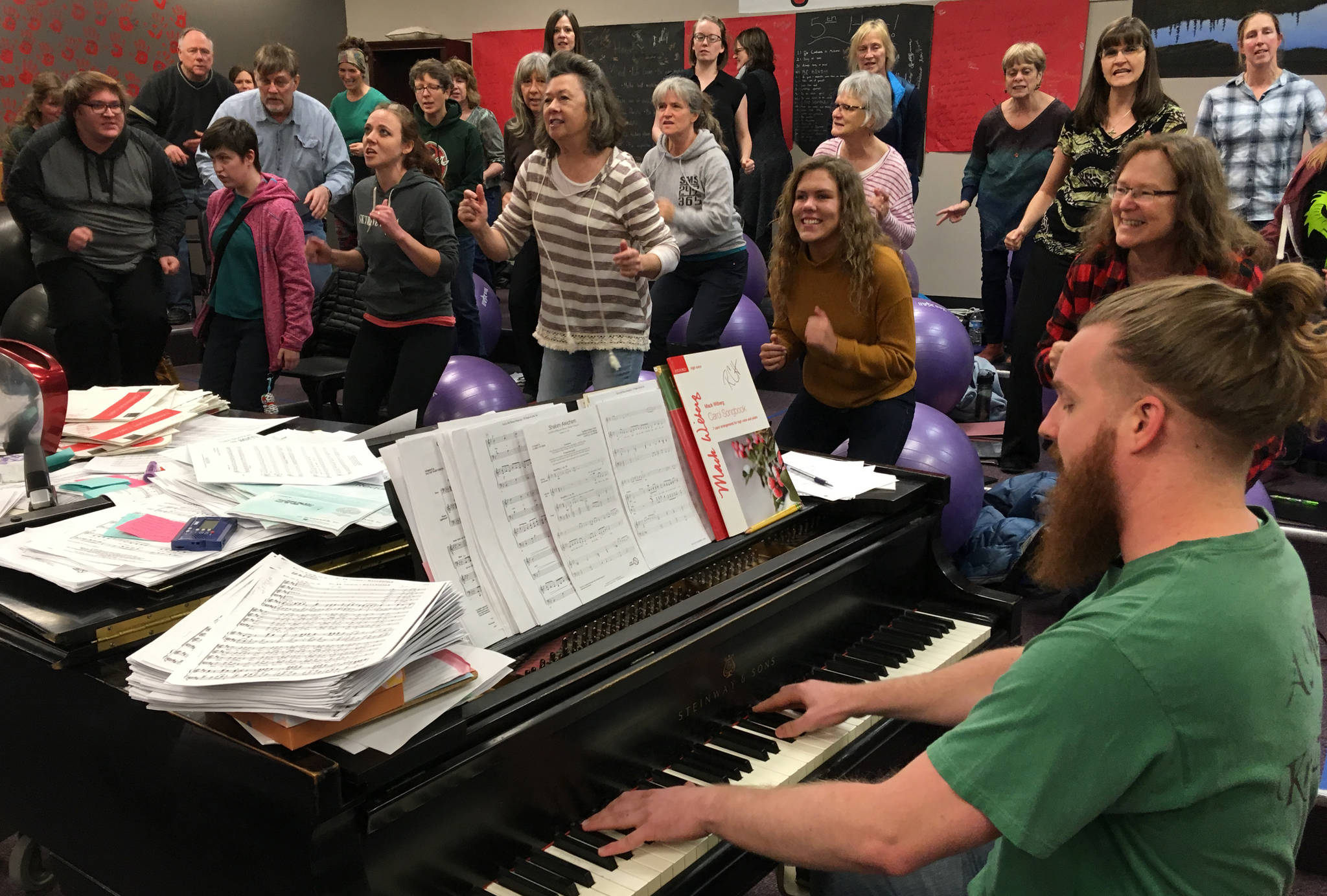 Simon Nissen, Kenai Central choir teacher and founder of the Kenai Peninsula Singers, warms up the singers at Kenai Central before a Monday rehearsal for the Evening of Christmas show. (Photo by Jeff Helminiak/Peninsula Clarion)