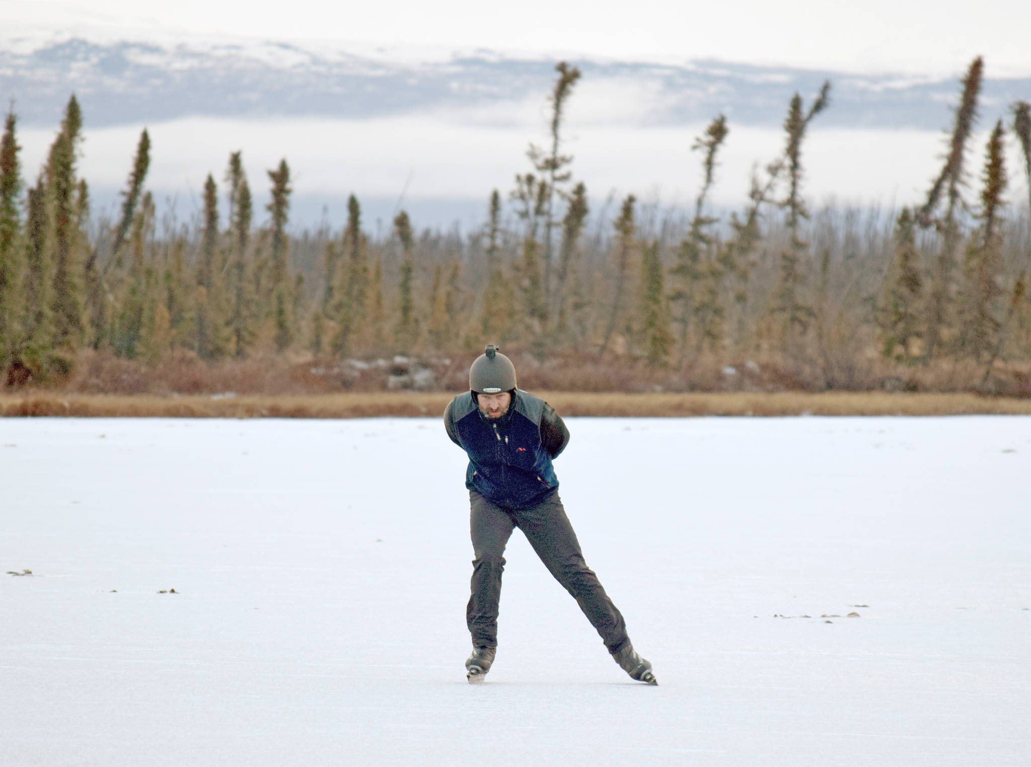 Trevor Davis skates on Bottenintnin Lake on Monday. (Photo by Jeff Helminiak/Peninsula Clarion)