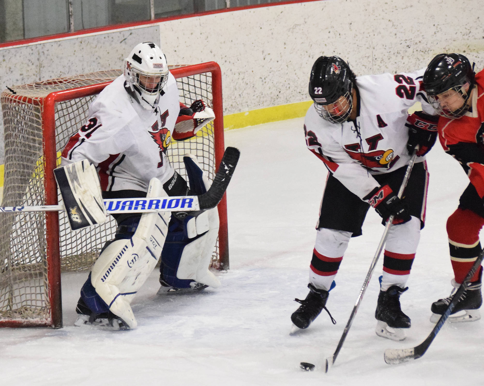 Kenai Central goaltender Carson Koppes keeps an eye on the puck Wednesday night against Juneau-Douglas as teammate Jacob Keels (22) plays keep away at the Kenai Multi-Purpose Facility. (Photo by Joey Klecka/Peninsula Clarion)