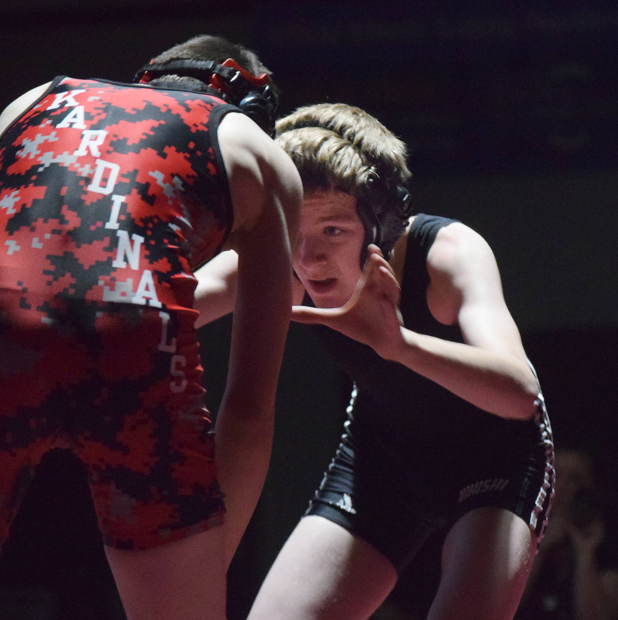 Nikiski freshman Griffin Gray sizes up Kenai Central freshman Talon Whicker in the 103-pound final at the Kachemak Conference Championship meet Dec. 8, 2018. (Photo by Joey Klecka/Peninsula Clarion)