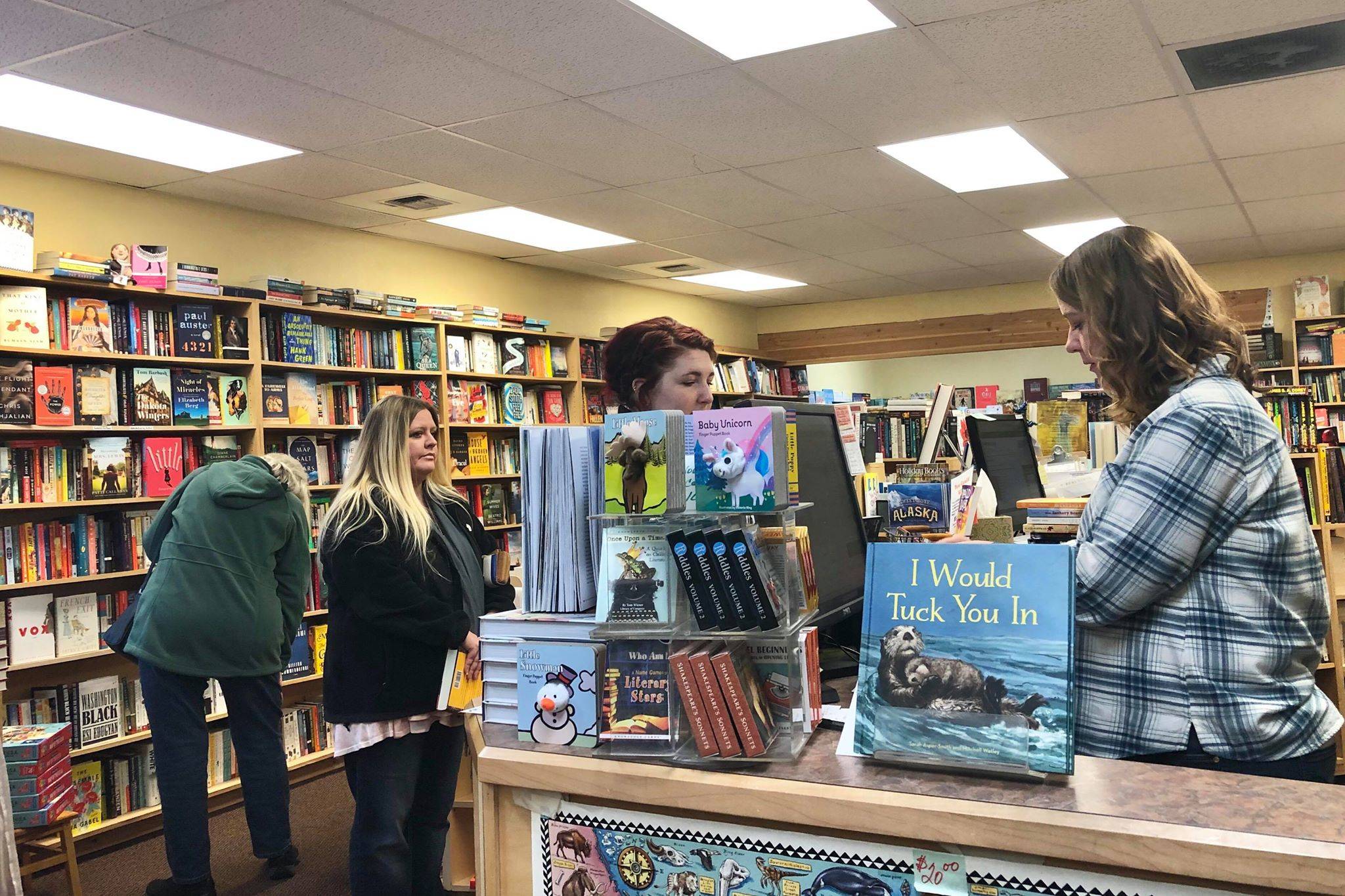 Shoppers make book purchases during the busy holiday shopping season at River City Books in Soldotna on Friday. (Photo by Victoria Petersen/Peninsula Clarion)