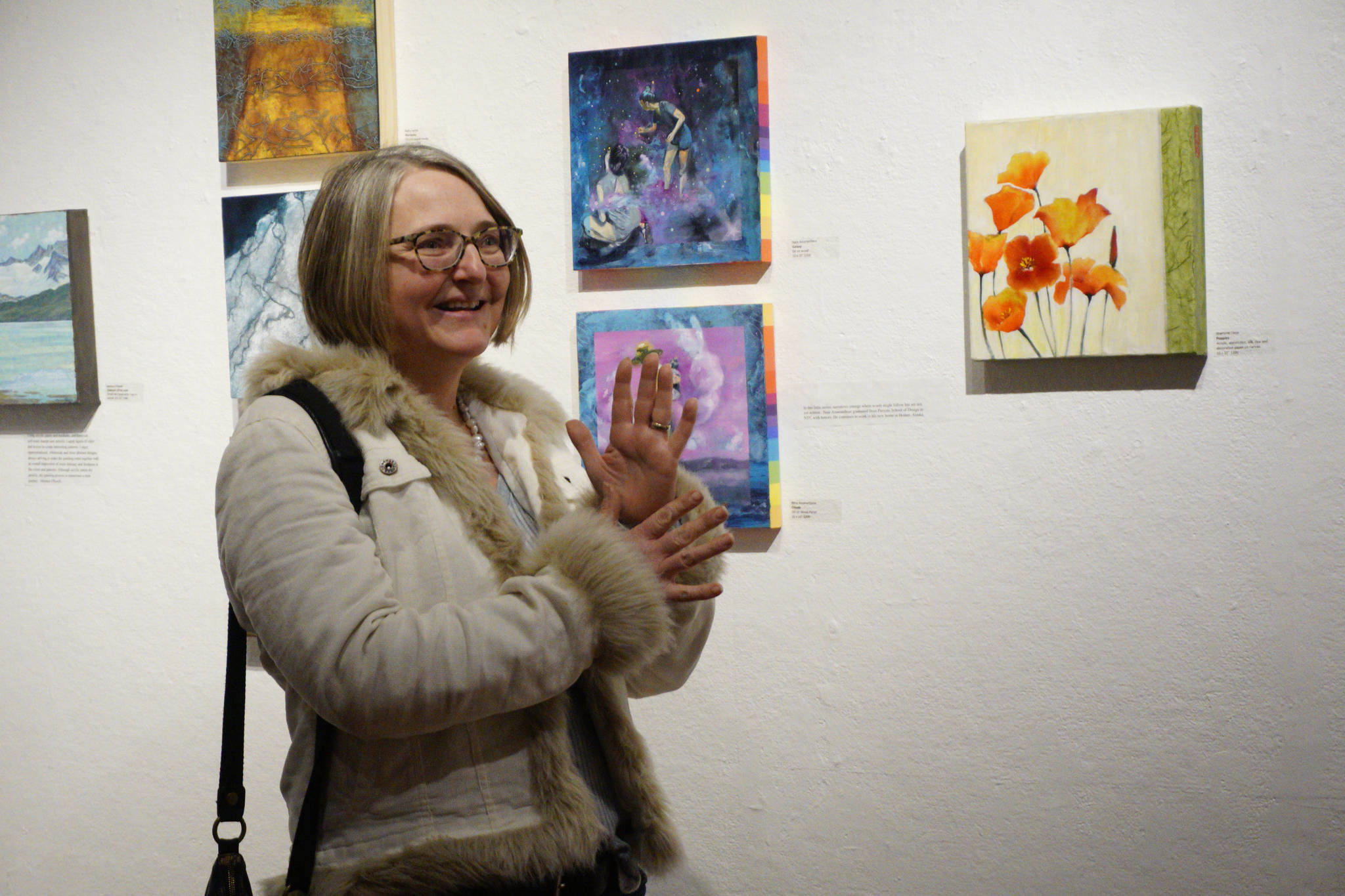 Sharlene Cline talks about her painting, “Poppies,” at the First Friday, Dec 7, 2018, opening of Bunnell Street Arts Center’s 10x10 show in Homer, Alaska. (Photo by Michael Armstrong/Homer News)