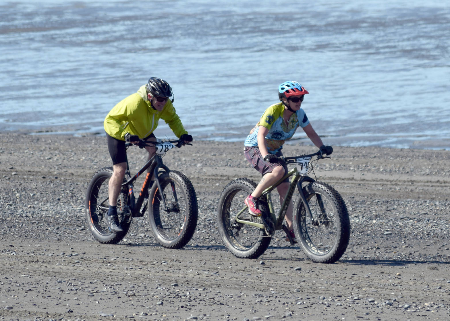 Catriona Reynolds finishes off a victory in the 10-mile bike at the Mouth to Mouth Wild Run and Ride on Monday, May 28, 2018, at the Kenai beach. On Reynolds’ tail is Sky Carver. (Photo by Jeff Helminiak/Peninsula Clarion)