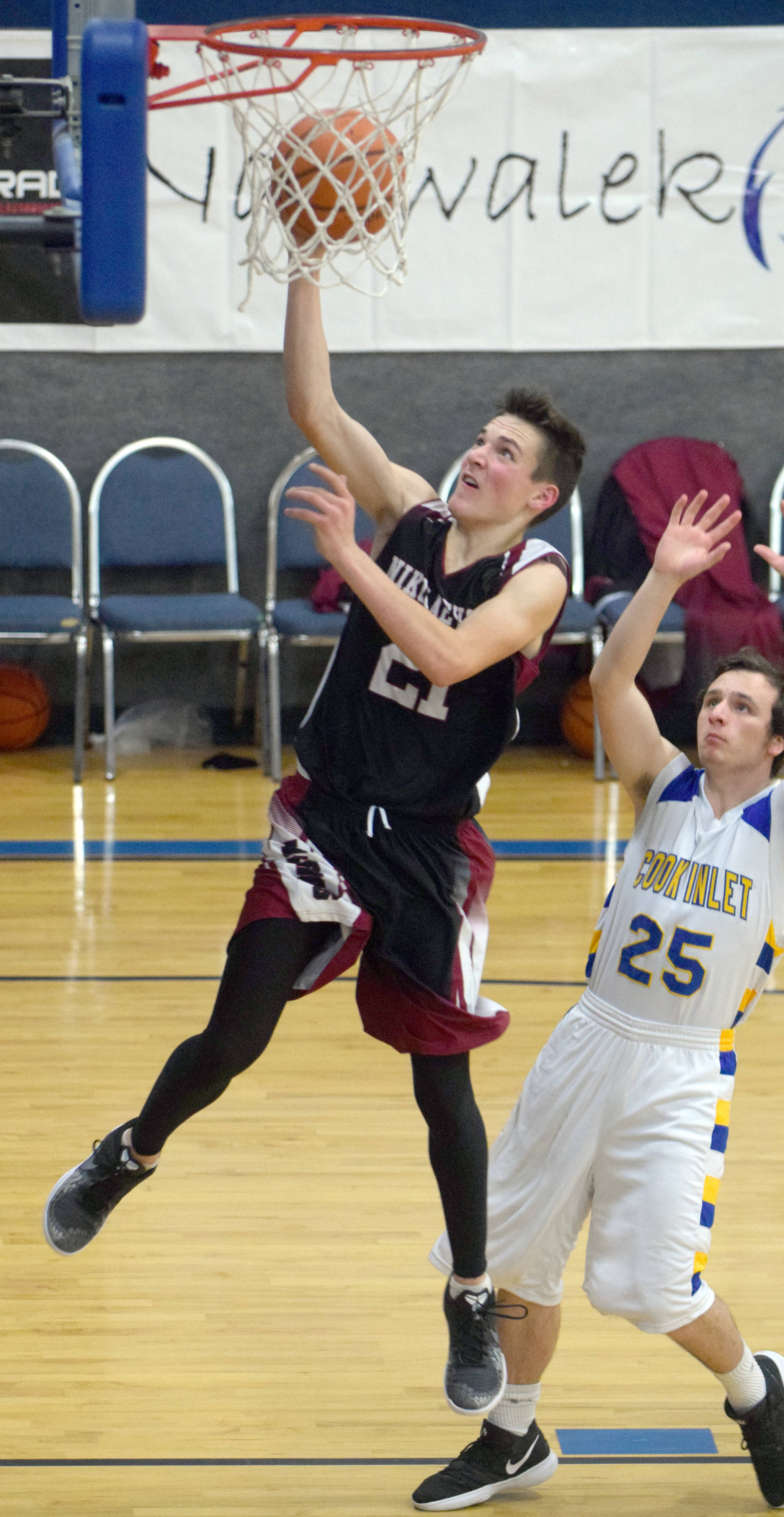 Nikolaevsk’s Justin Trail drives past Cook Inlet Academy’s James Anderson on Friday, Dec. 14, 2018, at Cook Inlet Academy in Soldotna. (Photo by Jeff Helminiak/Peninsula Clarion)