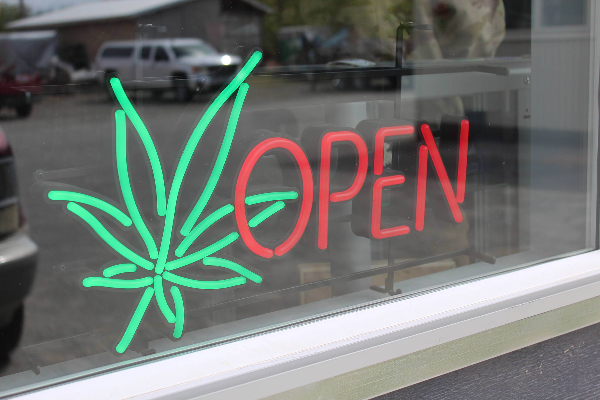 The open sign for Uncle Herb’s, Homer’s first marijuana retail store, lights up on opening day, Thursday, May 24, 2018 on Ocean Drive in Homer, Alaska. (Photo by Megan Pacer/Homer News)