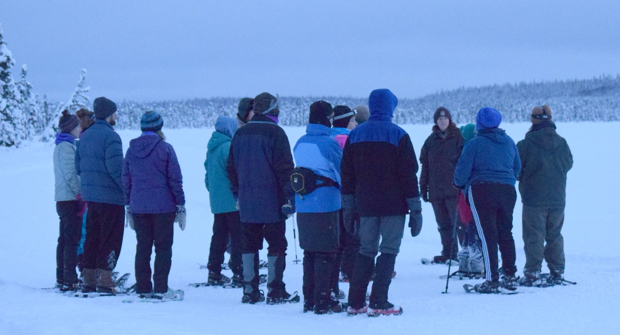Ranger Michelle Ostrowski, an education specialist at the Kenai National Wildlife Refuge, tells a group of winter solstice walkers at Headquarters Lake about wolves Friday, Dec. 21, 2018. (Photo by Jeff Helminiak/Peninsula Clarion)