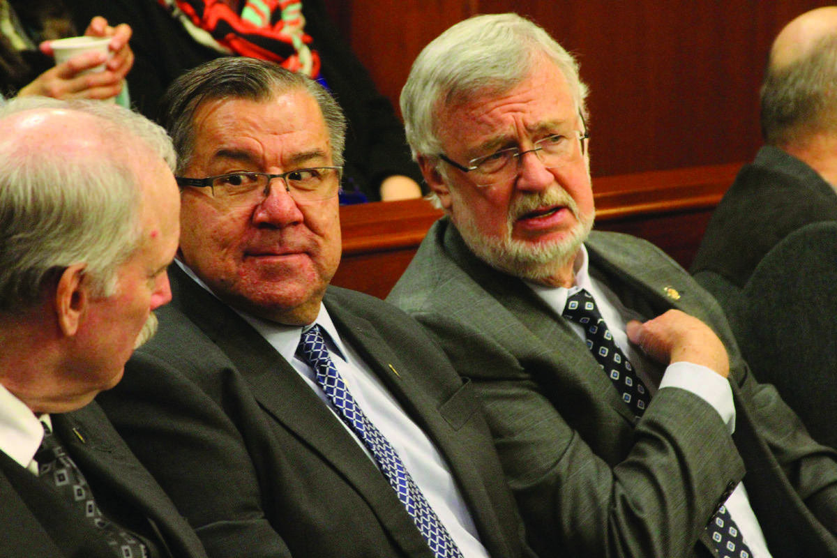 From left, Alaska state Sens. Bert Stedman, R-Sitka, Lyman Hoffman, D-Bethel, and Gary Stevens, R-Kodiak, sit in the House chamber to hear Gov. Bill Walker deliver his annual State of the State address on Jan. 18, 2017. After several years of budgets passing late and forcing education pink slip notices, Stevens, the Senate Education Committee chair, is introducing a bill to mandate an education budget by April 1. (Photo/Mark Thiessen/AP)