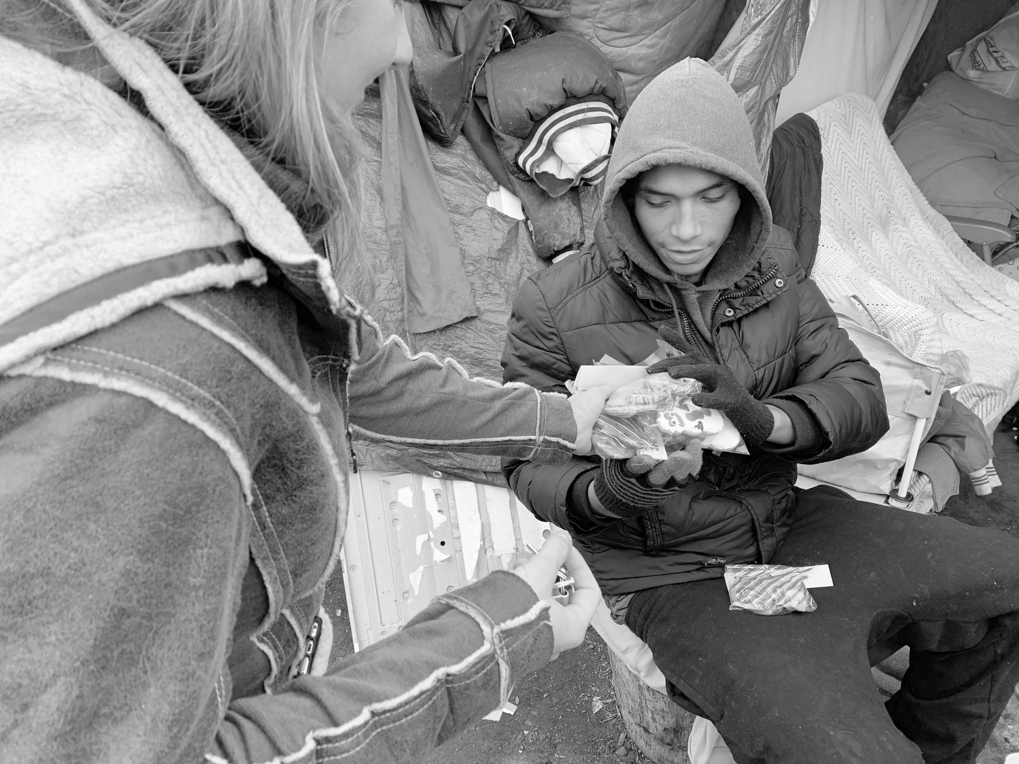 In this Dec. 13 photo, Kristina Tester, left, hands out cookies made by high school students to residents of a homeless camp made up mainly of Native Americans in south Minneapolis. Tester, who is both a medical student and a law student at the University of Minnesota, grew up near the camp. She began helping at the camp this summer as part of an elective rotation with the Native American Community Clinic in Minneapolis, and continues to volunteer. (AP Photo/Jeff Baenen)