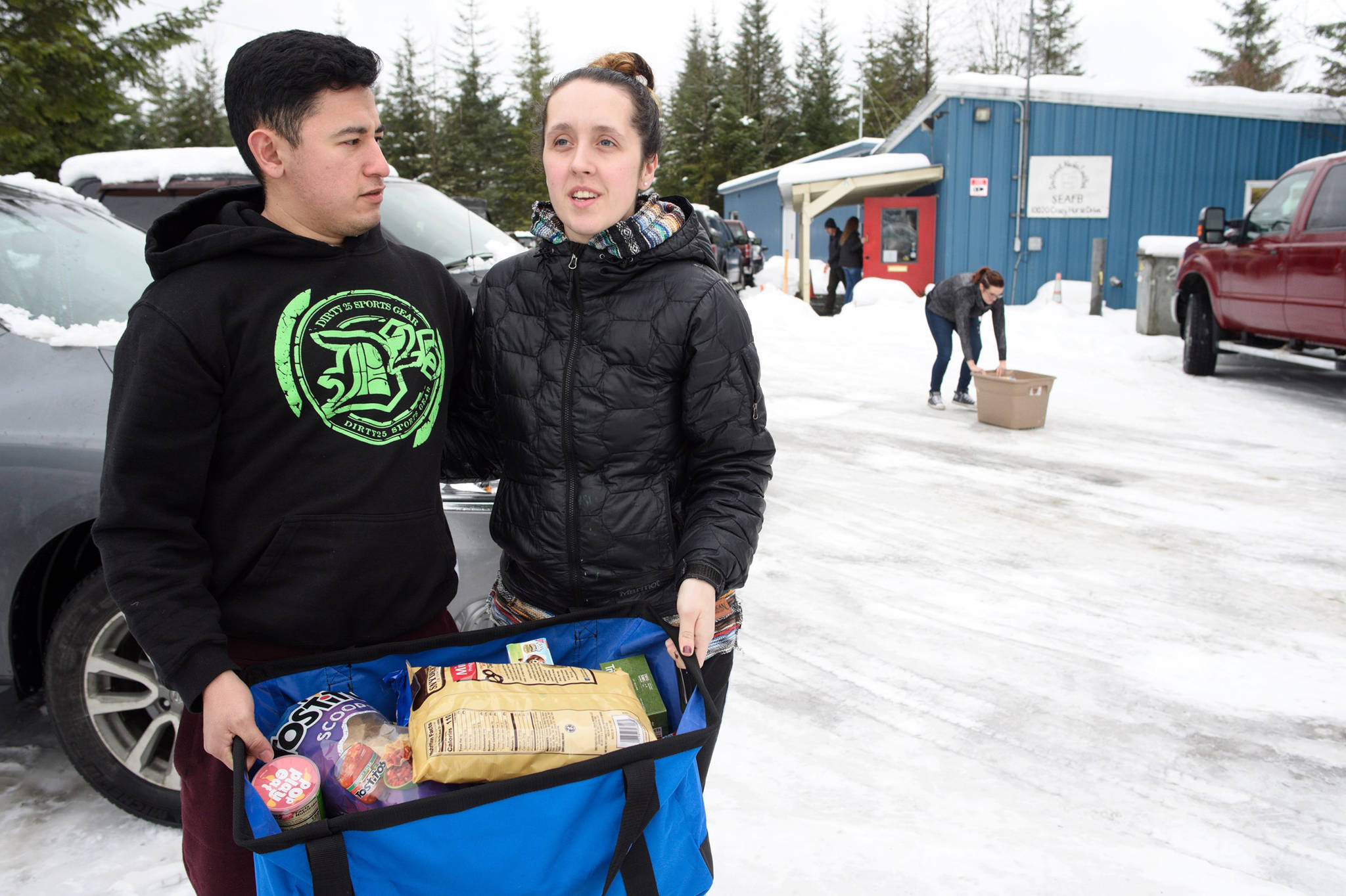 Jerry Arizpe and his wife, Jordan, hold a 33-pound bag of food they picked up at the Southeast Alaska Food Bank on Monday, Jan 21, 2019. Arizpe is a U.S. Coast Guardsman at Station Juneau and is not currently receiving a paycheck because of the partial federal shutdown. (Michael Penn | Juneau Empire)
